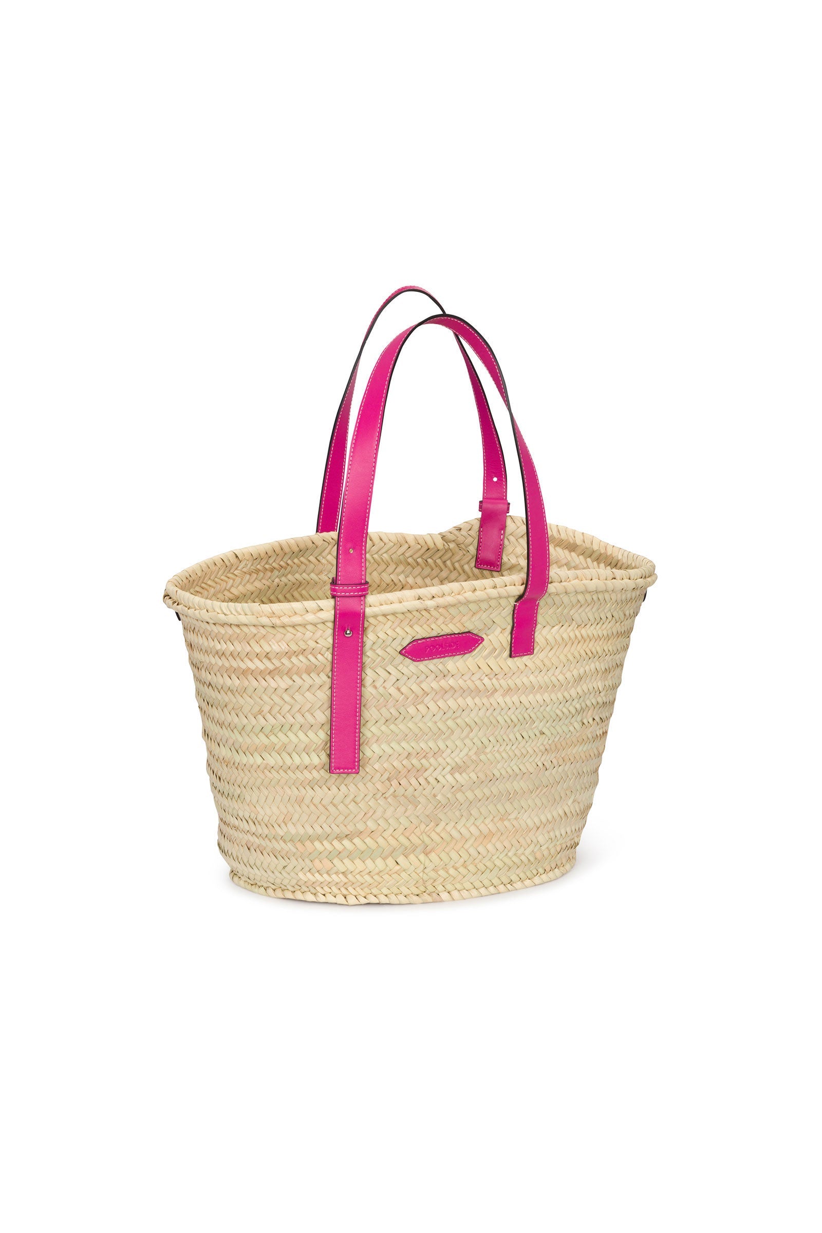 A woven straw tote bag with bright pink leather handles and a matching pink leather patch on the front, displayed on a white background.