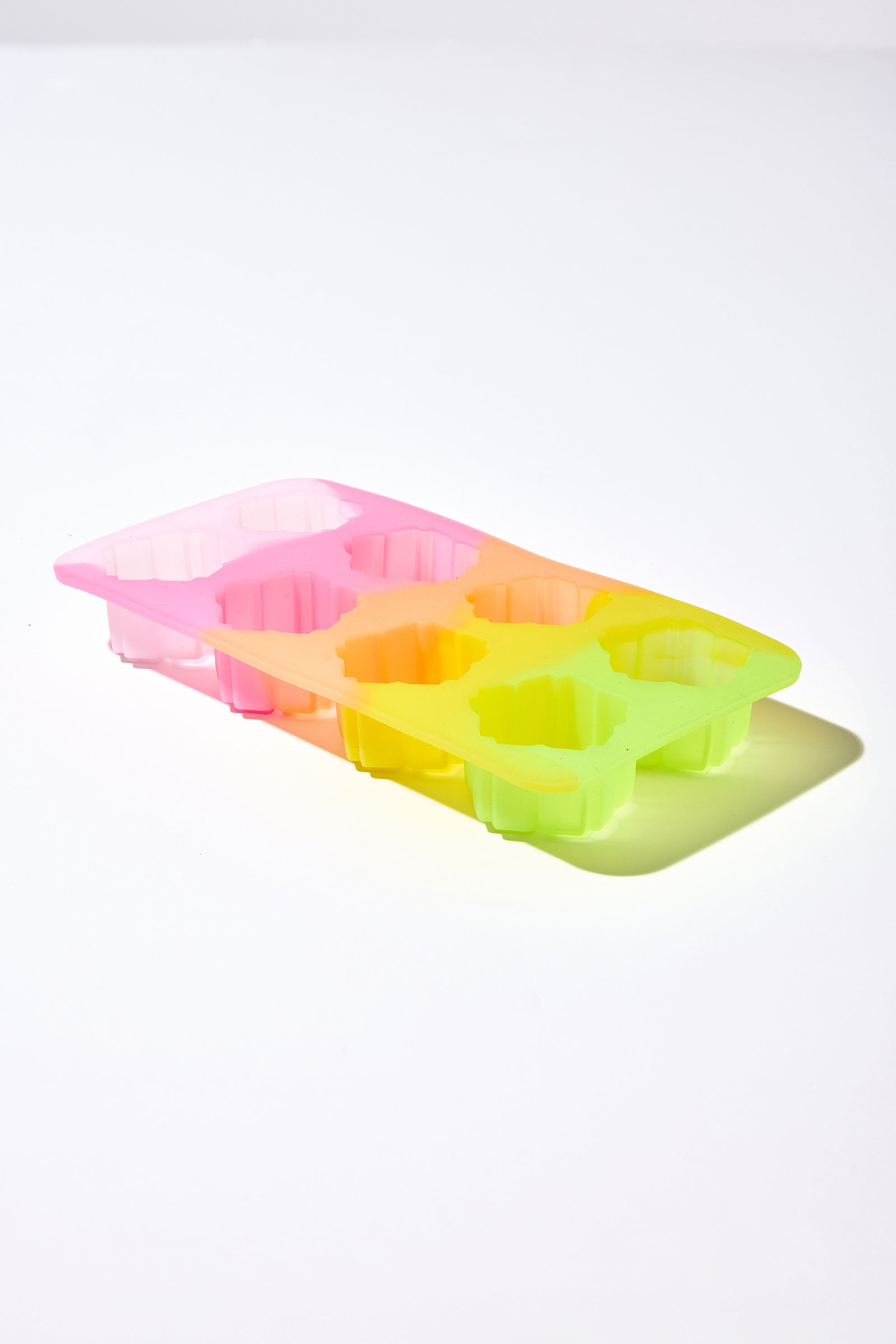 The Cocktail Glass Set with Silicone Floret Mold features a colorful, flower-shaped silicone mold in pink, orange, and green hues, displayed on a white surface with its shadow on the right.