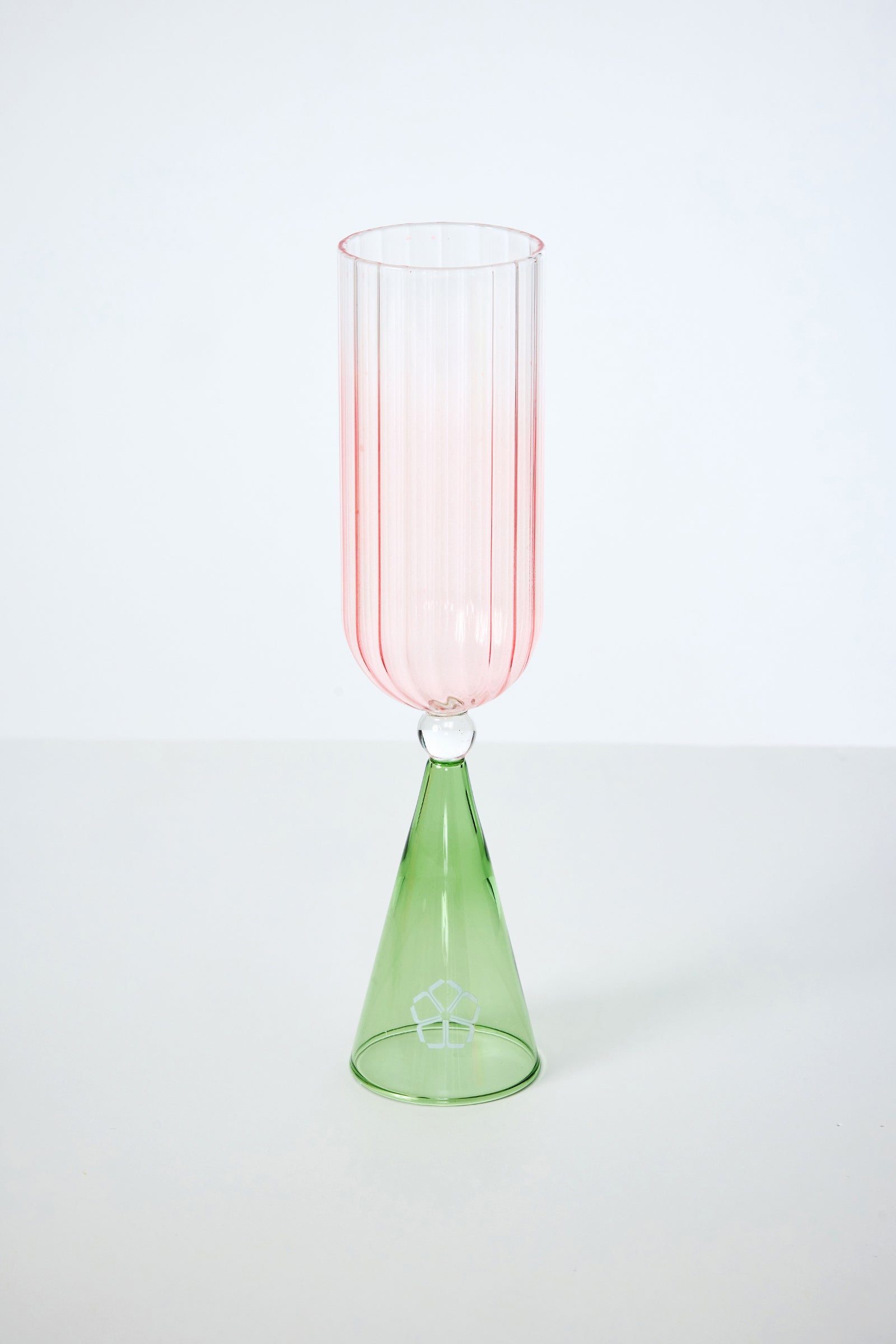 A tall, elegant glass from the Cocktail Glass Set with Silicone Floret Mold features a pink ribbed cup, a green conical base, and a clear glass sphere in between, all set against a plain white background.