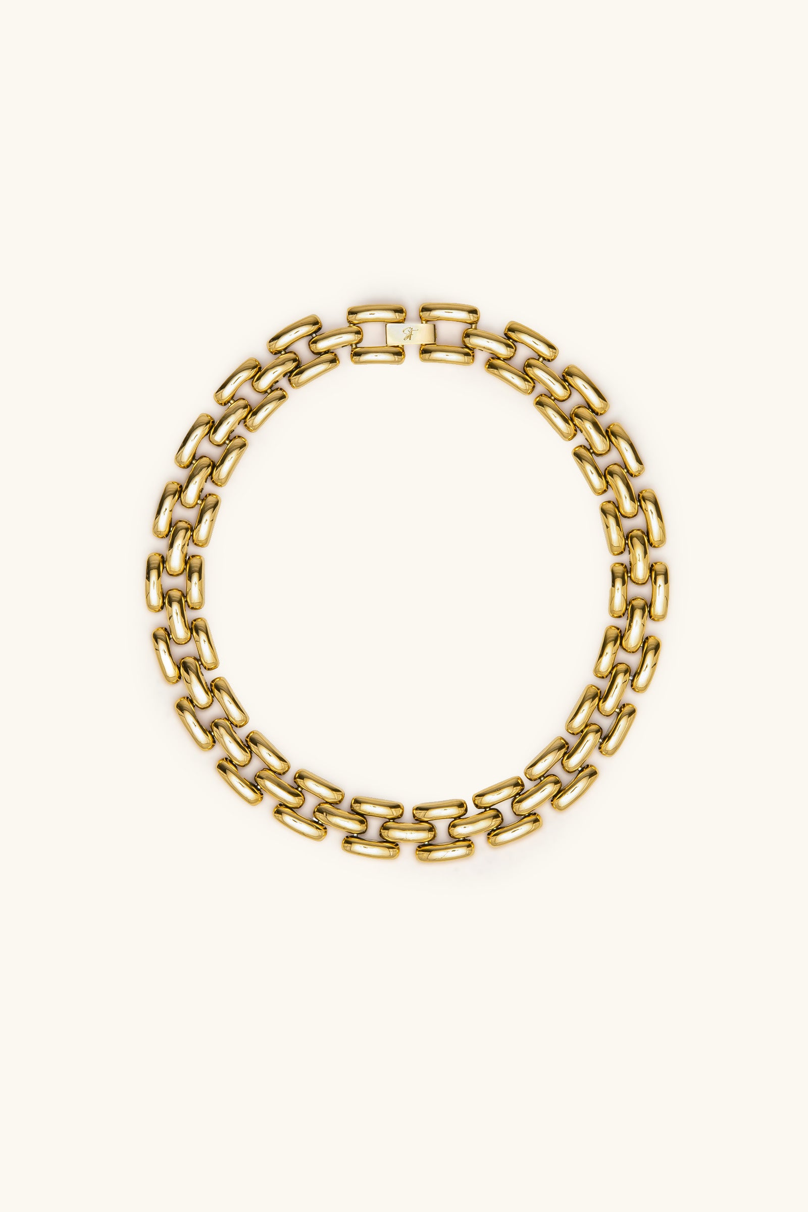 The Phoebe 17 Necklace in gold, featuring bold, thick rectangular links arranged in a circle on a plain light background. Displayed flat, it highlights its striking interlocking link design.