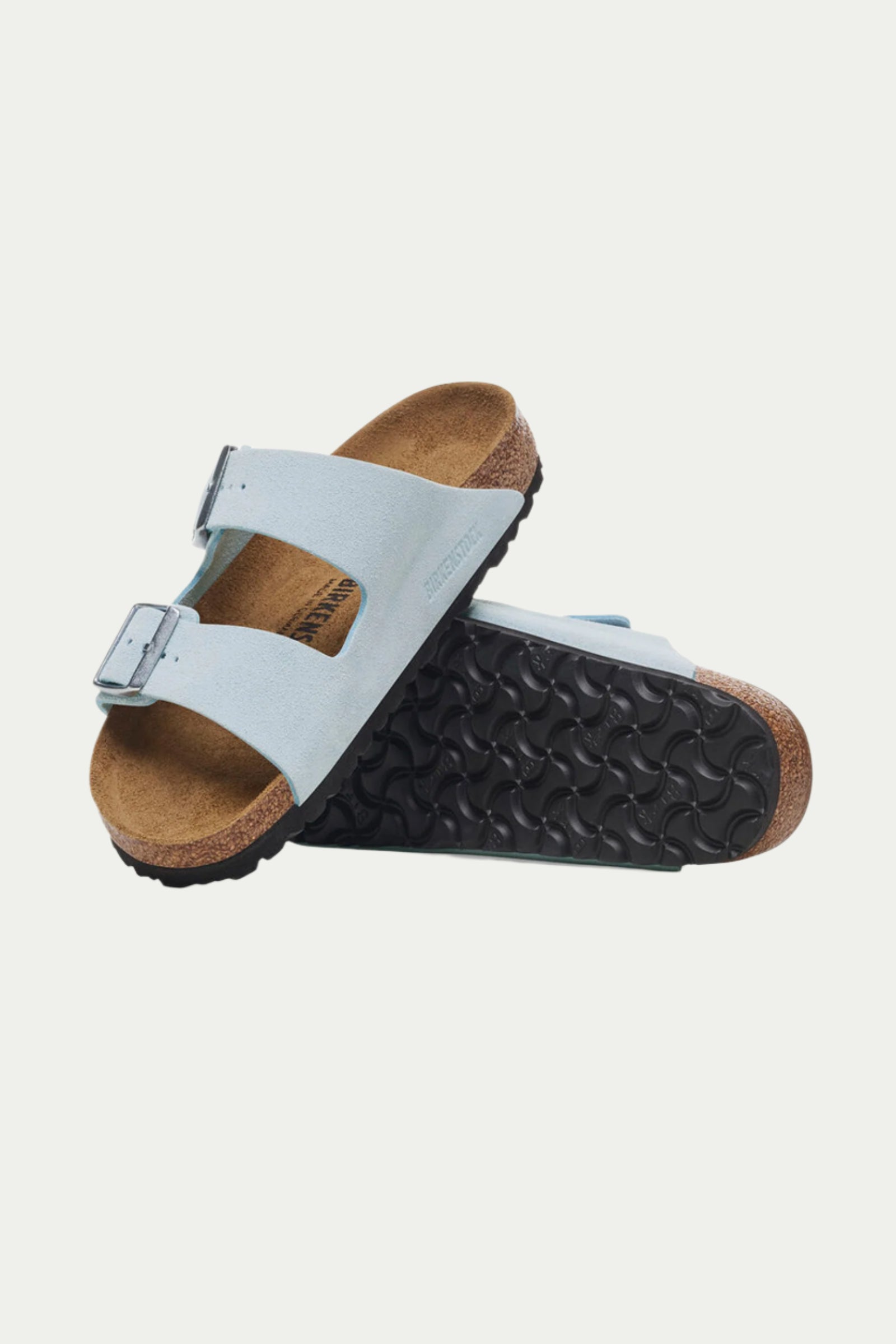 The Womens Arizona Suede Sandal features light blue suede, two buckle straps, cork footbeds, and a textured black sole; one sandal stands upright to display the sole.