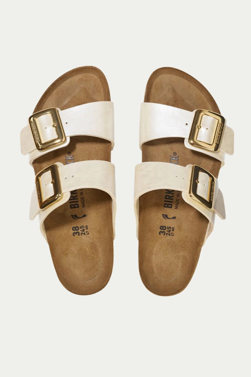 Womens Sydney Luxe Buckle Sandal: a pair of white Birkenstock sandals featuring two wide straps and large gold buckles, shown from above on a plain light background.