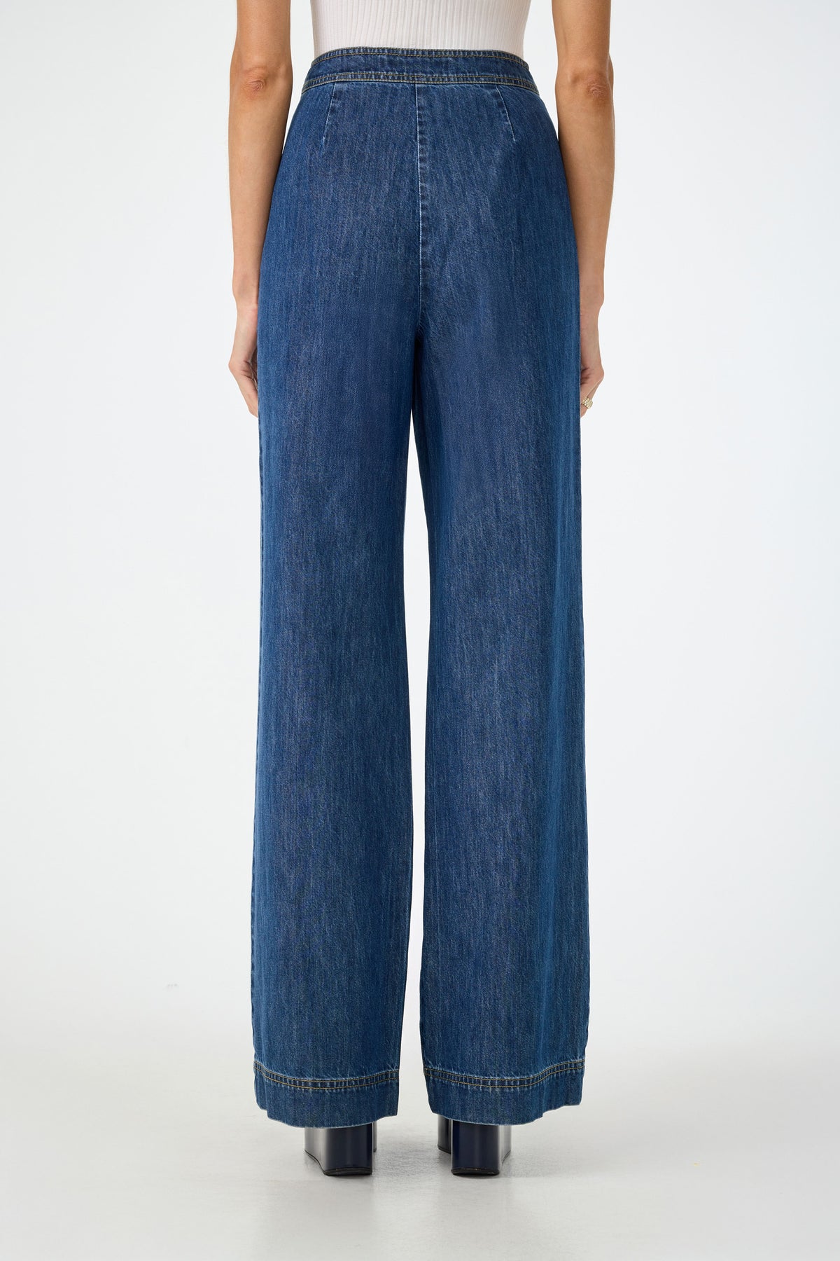 A person models the Ferrer Wide Leg Jean, standing with their back to the camera against a plain white background, paired with black heeled boots.