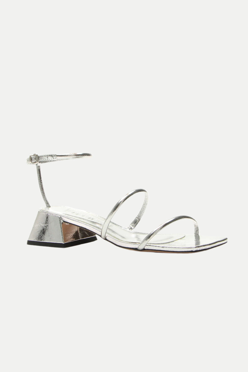 The Burano Silver Strappy Heeled Sandal features a metallic silver finish, low geometric block heel, two thin front straps, and an ankle strap with a small buckle, displayed on a white background.