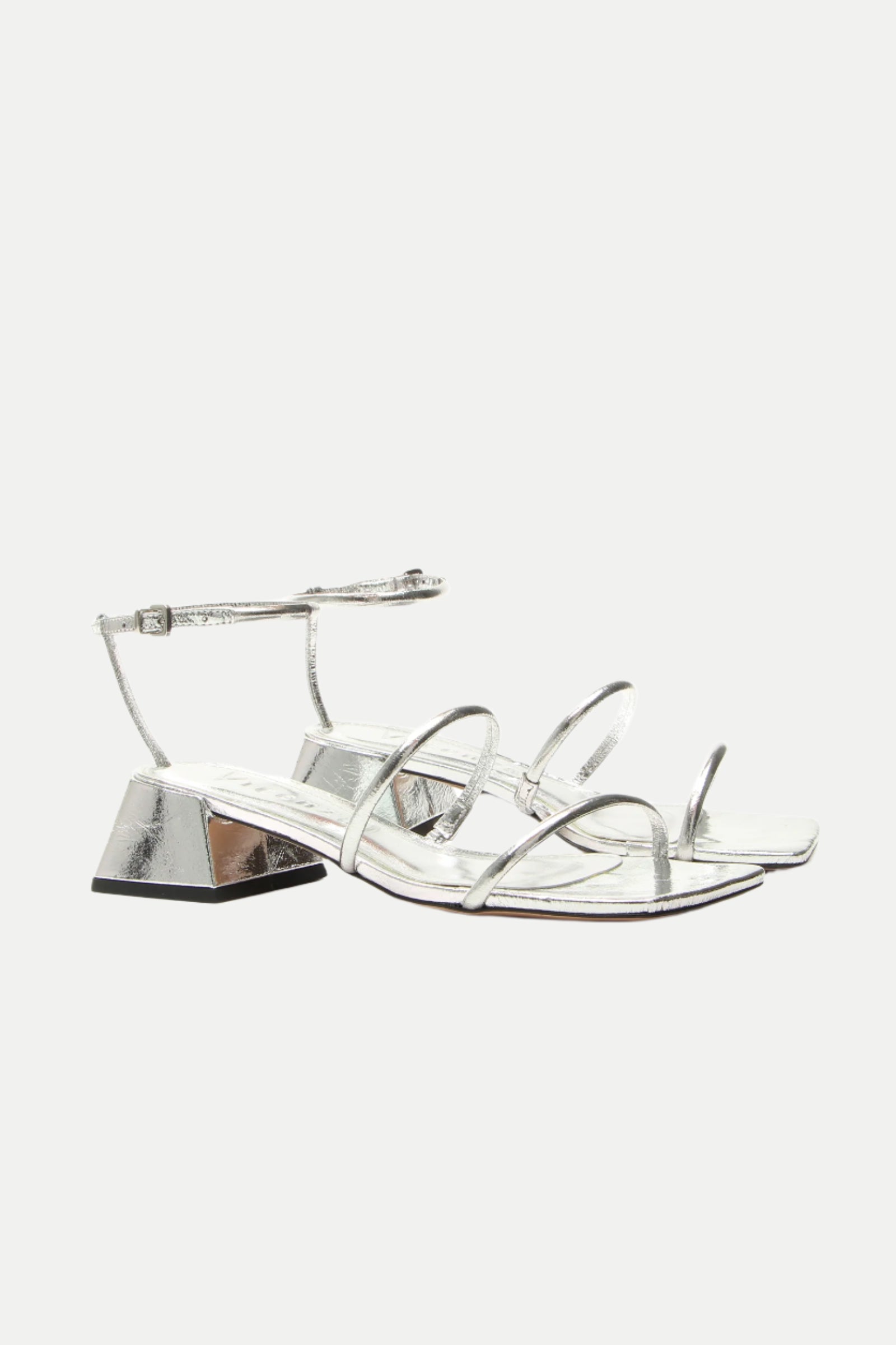 Burano Silver Strappy Heeled Sandal: A pair of silver sandals with low geometric block heels and ankle straps, shown on a white background.