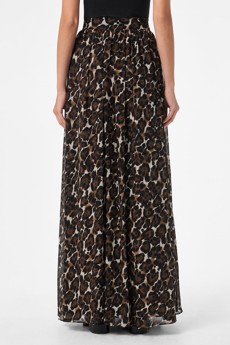 A person shown from the back wears the Bersha Skirt, a long, flowing skirt featuring a black, brown, and beige leopard print pattern, paired with a black top.
