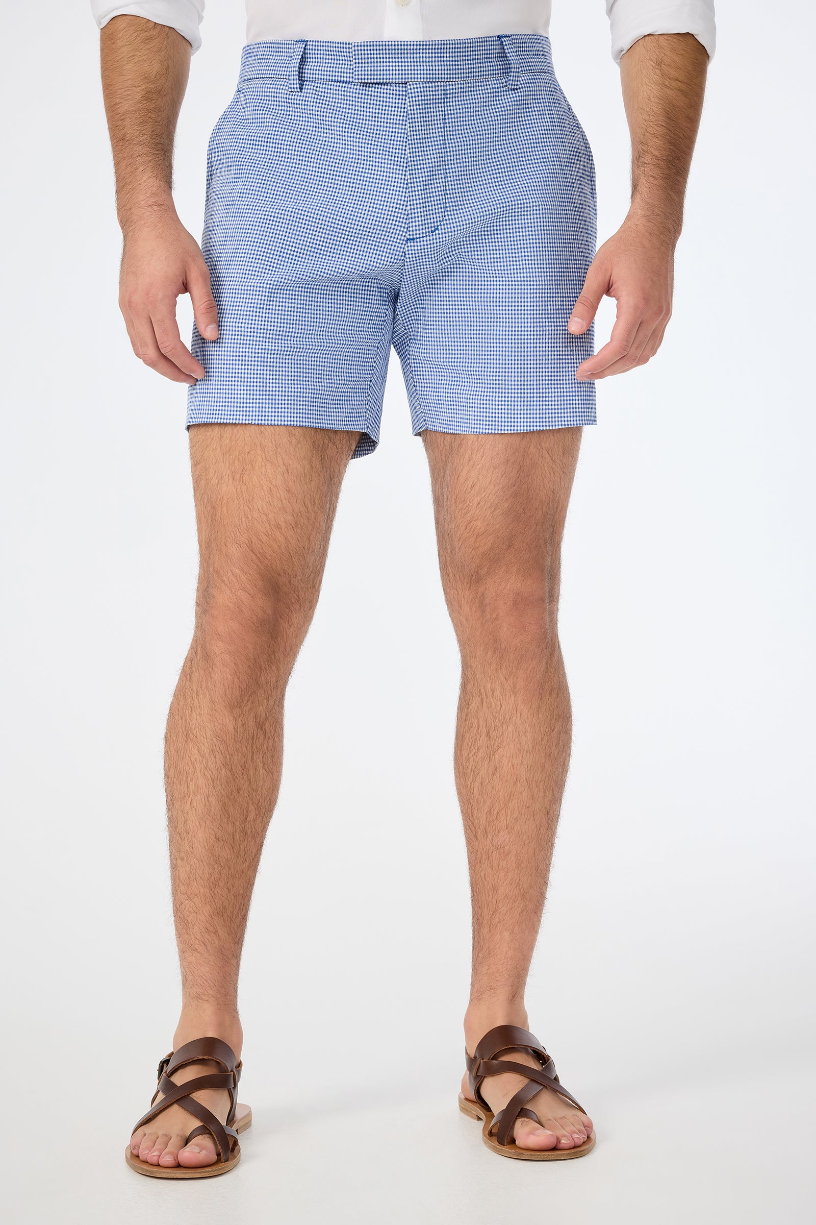 A man stands against a white background, wearing the Roger Short in Ocean Gingham. The image is cropped just below his shoulders to highlight the shorts and legs.