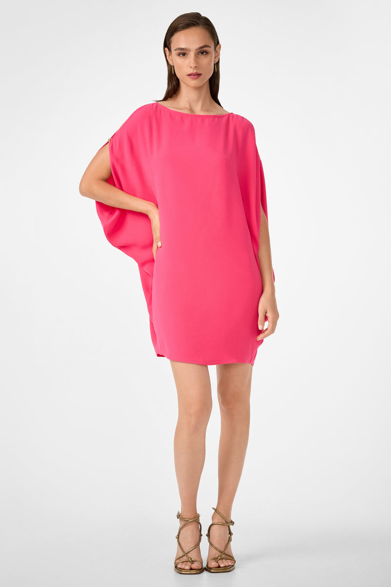 A woman with straight brown hair and a neutral expression stands against a plain background, wearing the bright pink Razu Short Split Sleeve Mini Dress and strappy high-heeled sandals.
