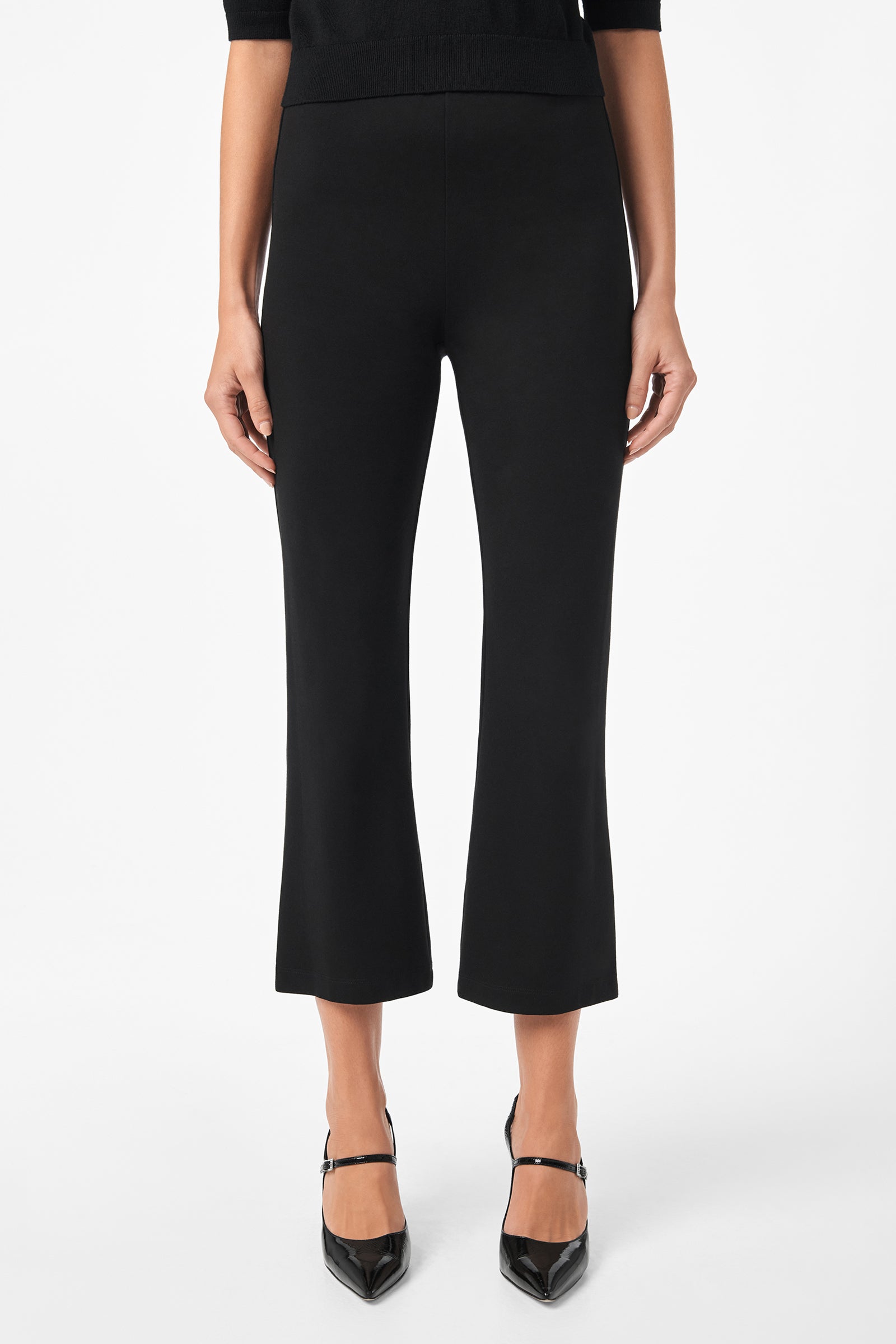 A person is wearing Sorrel Kick-Flare Pants in black with a slight flare at the ankle and black pointed-toe heels, posed against a white background. Only the lower torso and legs are shown.