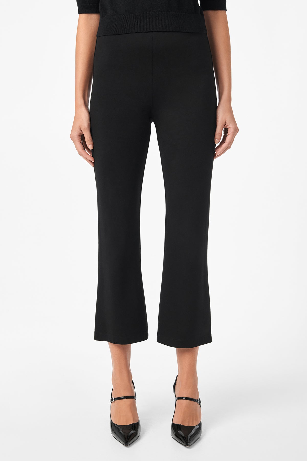 A person is wearing Sorrel Kick-Flare Pants in black with a slight flare at the ankle and black pointed-toe heels, posed against a white background. Only the lower torso and legs are shown.