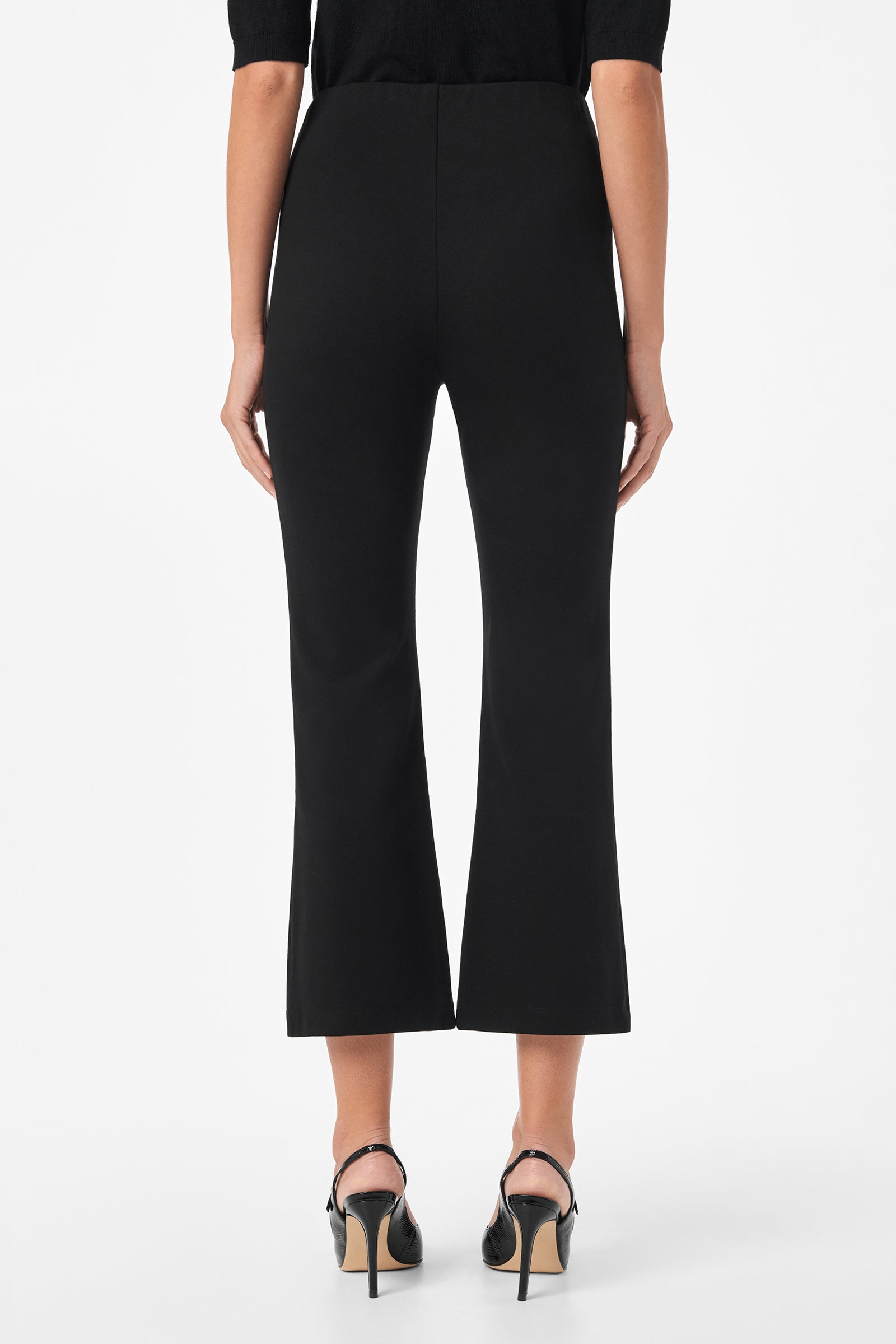 A person wearing Sorrel Kick-Flare Pants and black heeled sandals, shown from the back against a plain white background.