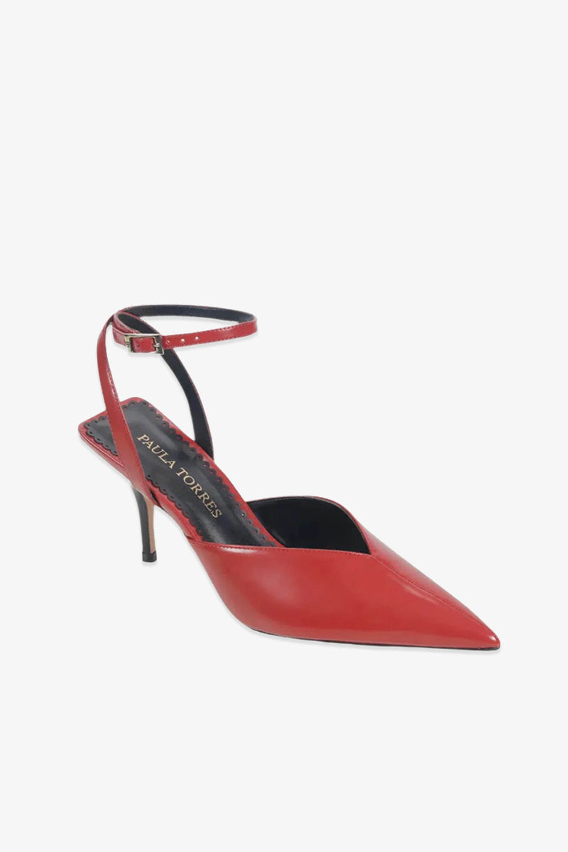 A single Paula Torres Cannes Pump luxury shoe in red, showcasing a pointed-toe slingback silhouette with an ankle strap and a black insole featuring the Paula Torres label, displayed against a white background.