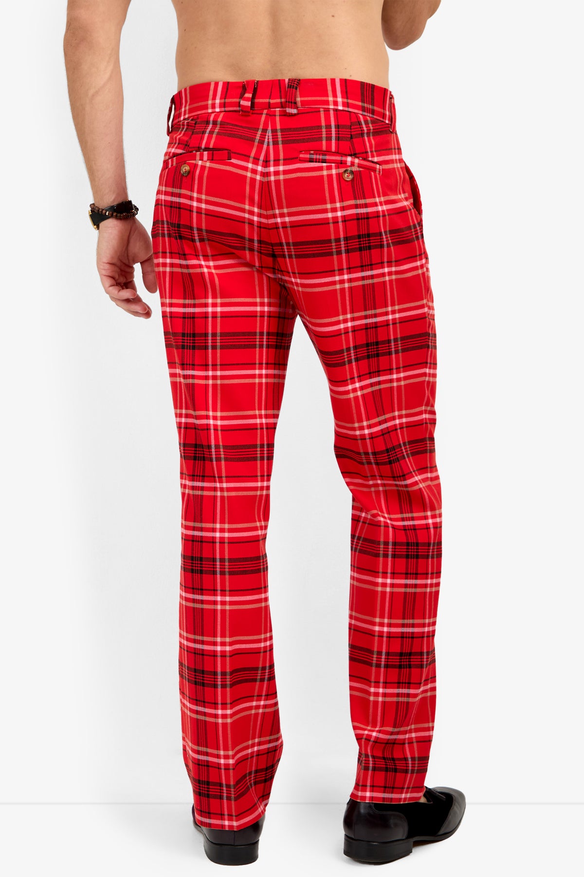 A person seen from the back wearing Dirk Trouser in red plaid, black shoes, and a bracelet, standing against a plain white background.