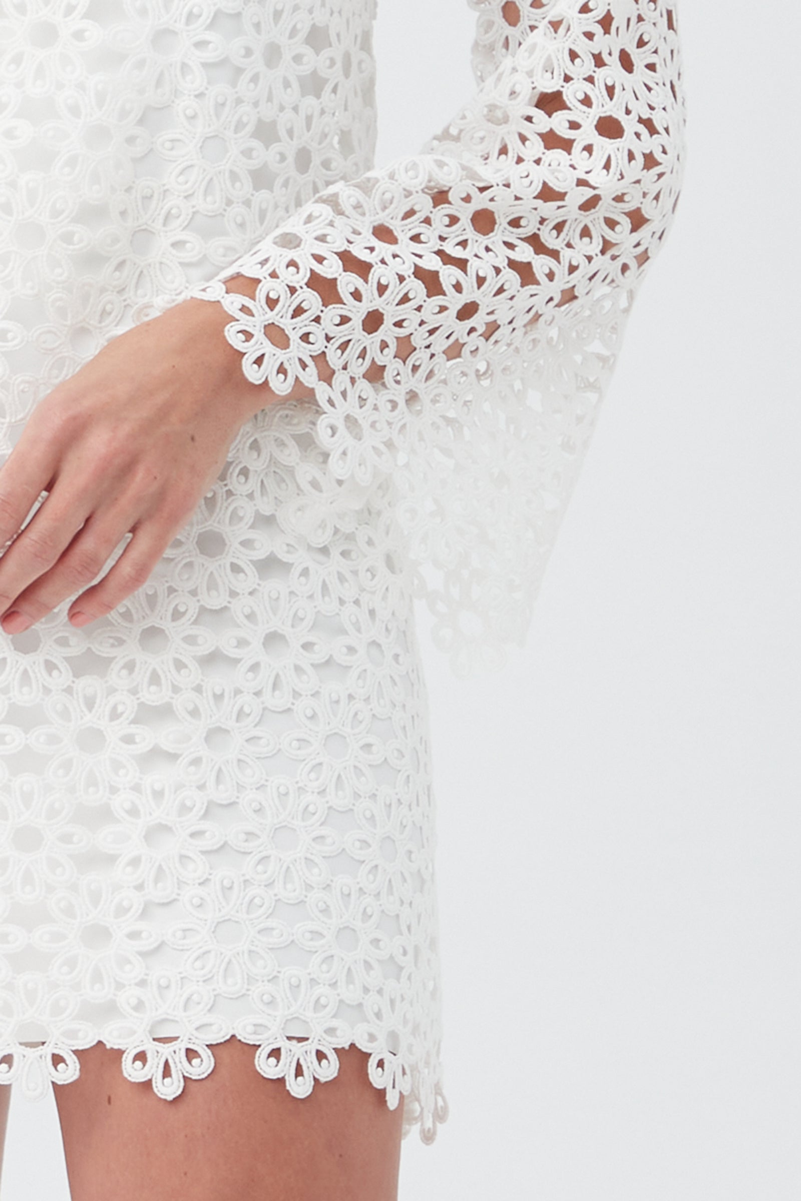 A woman models the Women's Chateau Lace Long Sleeve V-Neck Swim Cover-Up Dress with floral lace, bell sleeves, and scalloped edges—shown from torso to lower face against a plain background.