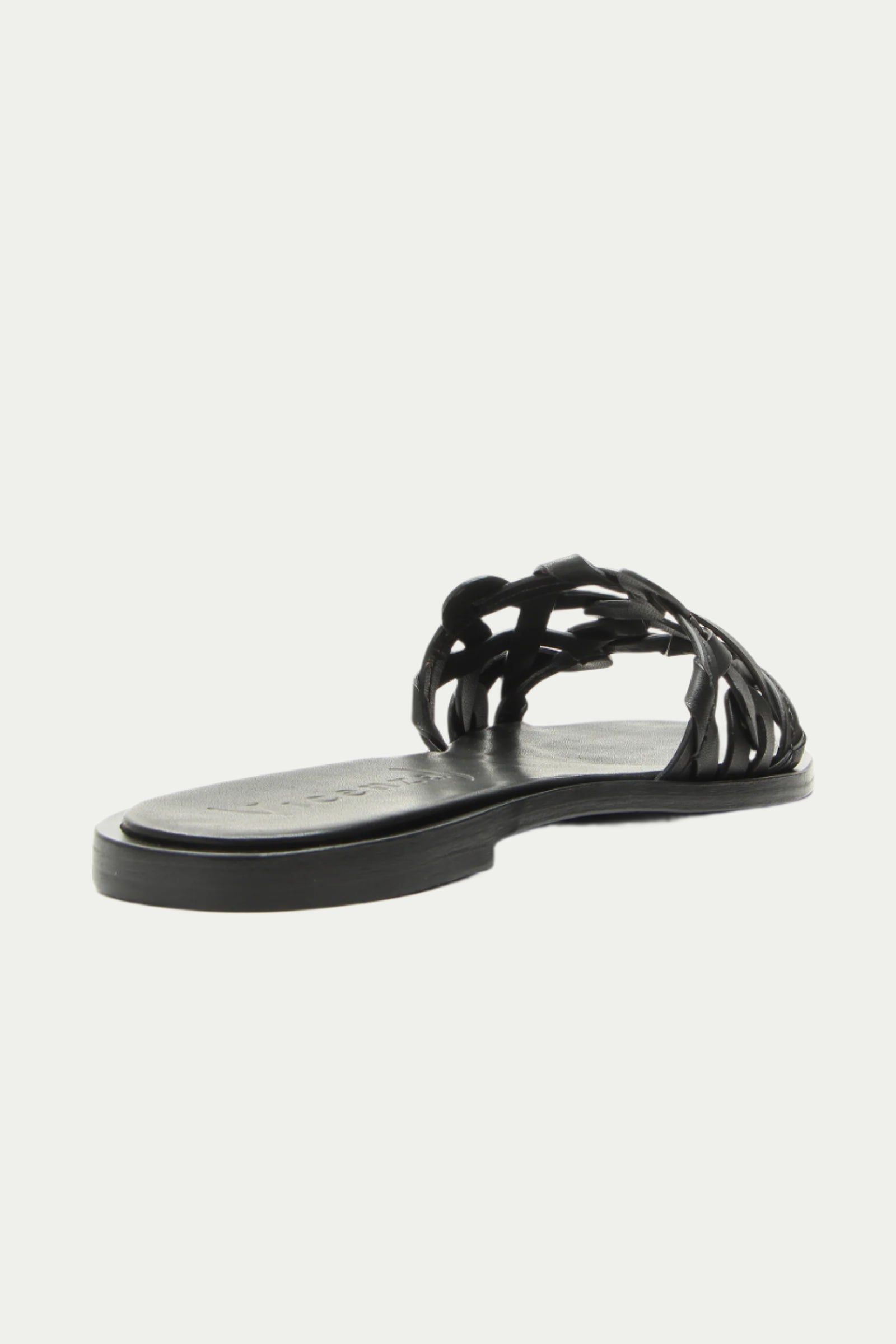 The Haia Black Woven Leather Slide Sandal features an open toe and braided straps, shown from a rear angled view against a white background.