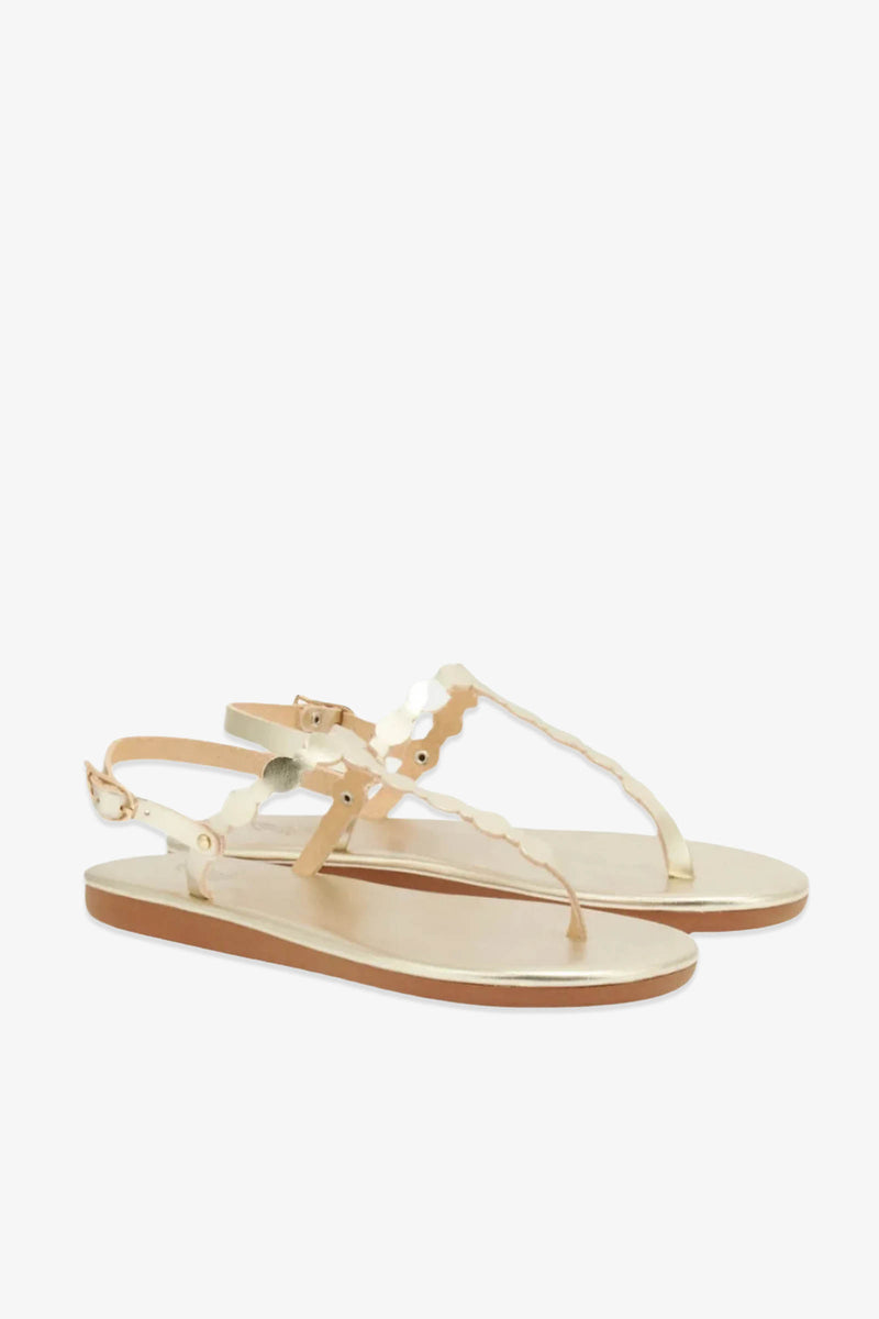 Crafted from leather, the Ancient Greek Sandals Velos feature beige flat soles, brown outsoles, and metallic scalloped straps with a buckle closure at the heel, evoking the enduring style of classic ancient Greek sandals.