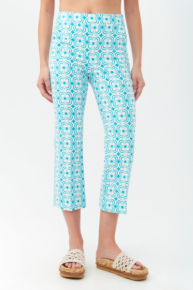 Someone wearing the Flaire 2 Pant in Blue Grotto with beige woven platform sandals, standing against a plain white background.