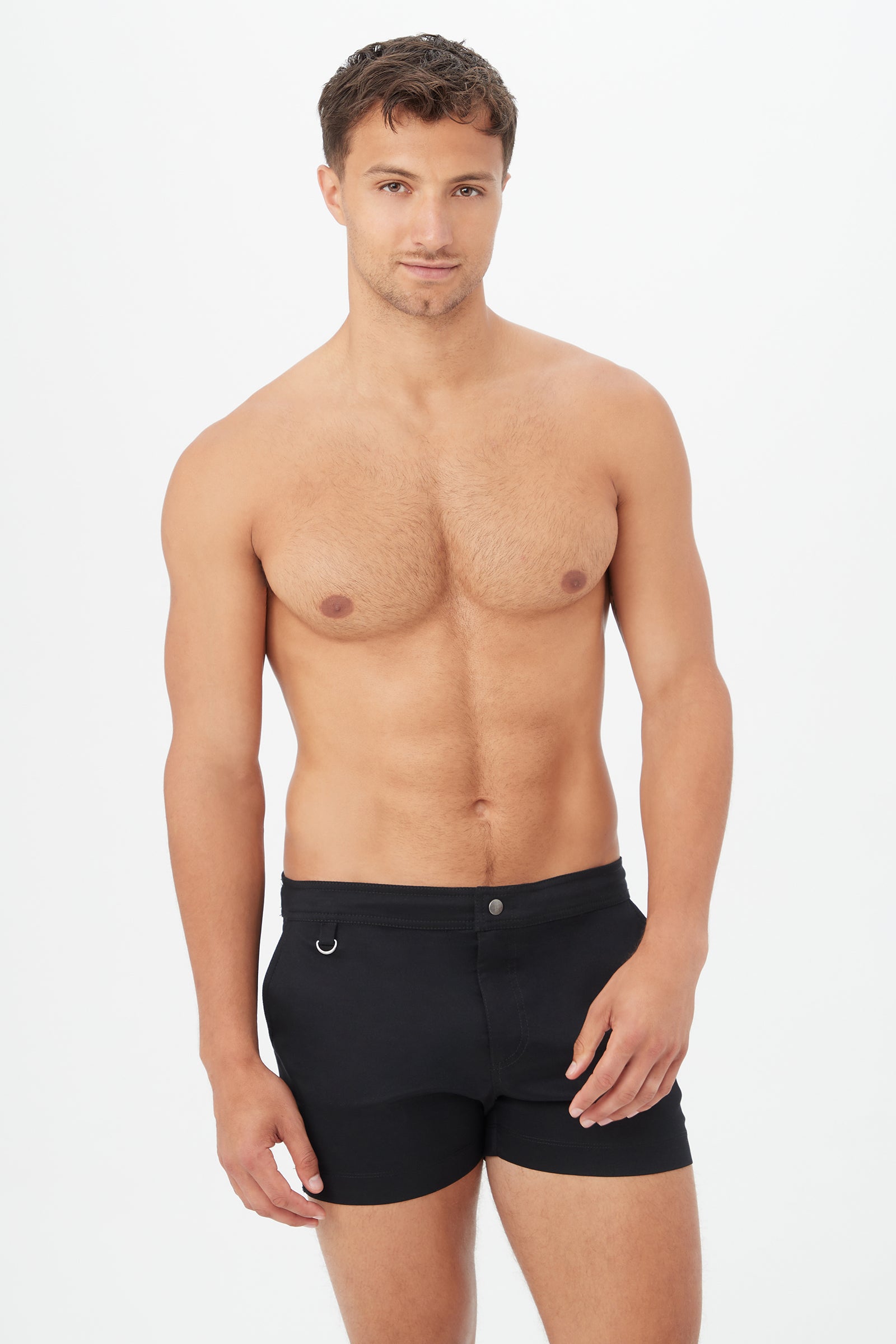 A man with short brown hair poses shirtless against a plain white background, wearing black Chico Swim Trunk - Metallic Swim Woven.