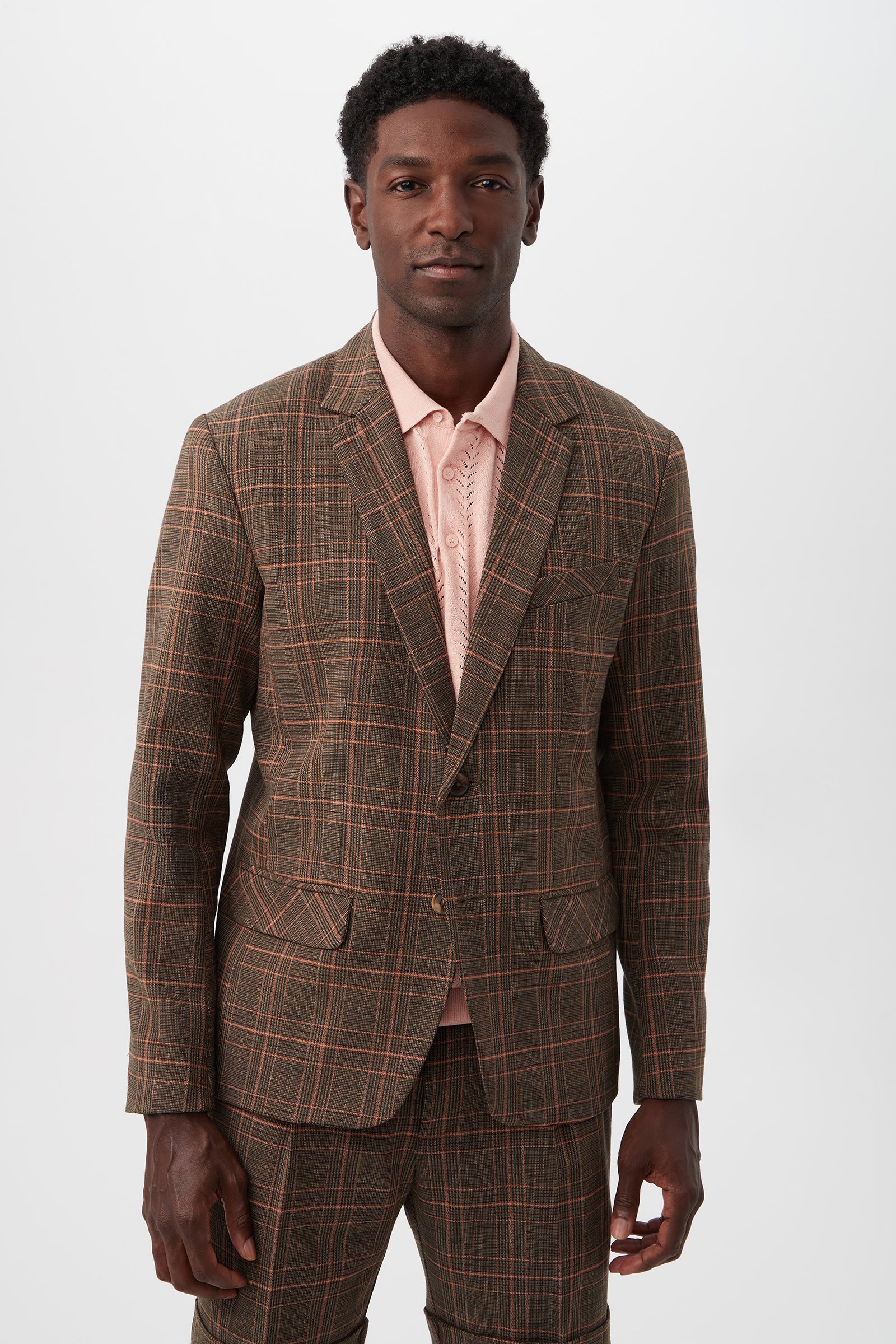 A man wearing the Thurston 2 Blazer - Chaka Check Plaid and matching pants over a light pink collared shirt stands facing forward against a plain white background.