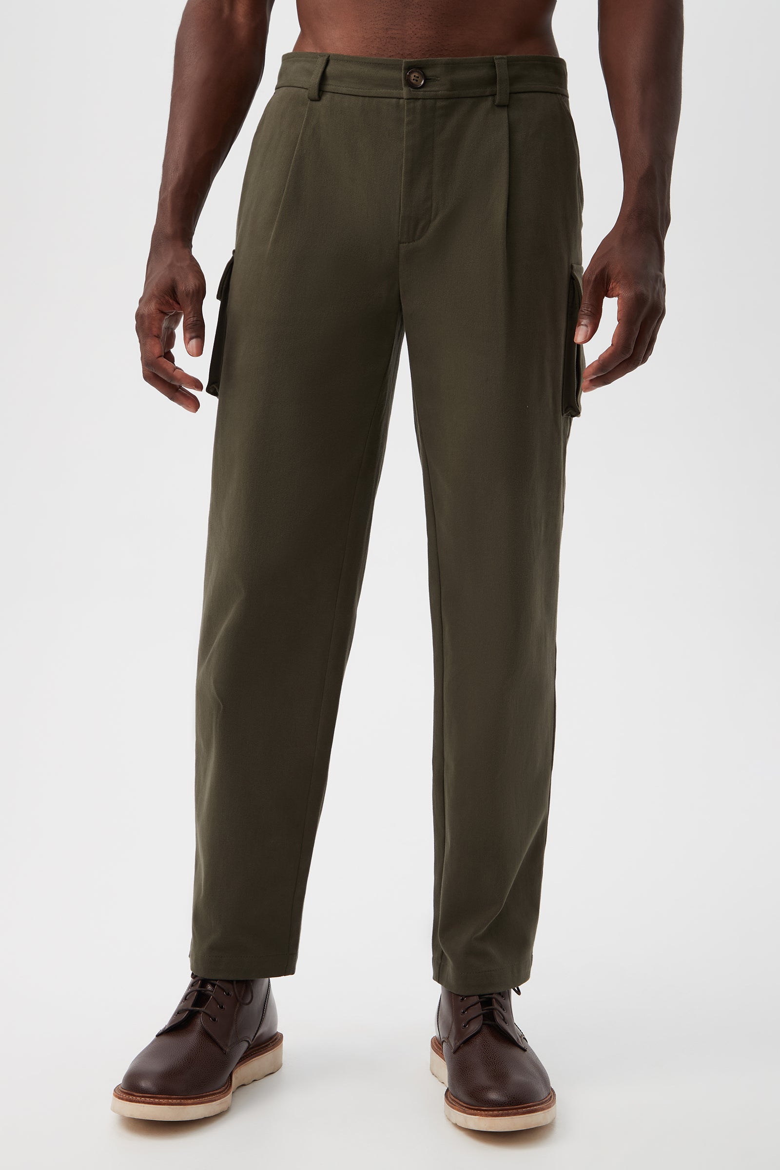 Wearing the Lincoln Heights Cargo Trouser - Brushed Twill in Crocodile, paired with brown lace-up boots, a person stands against a plain white background. The photo is cropped from mid-chest down.