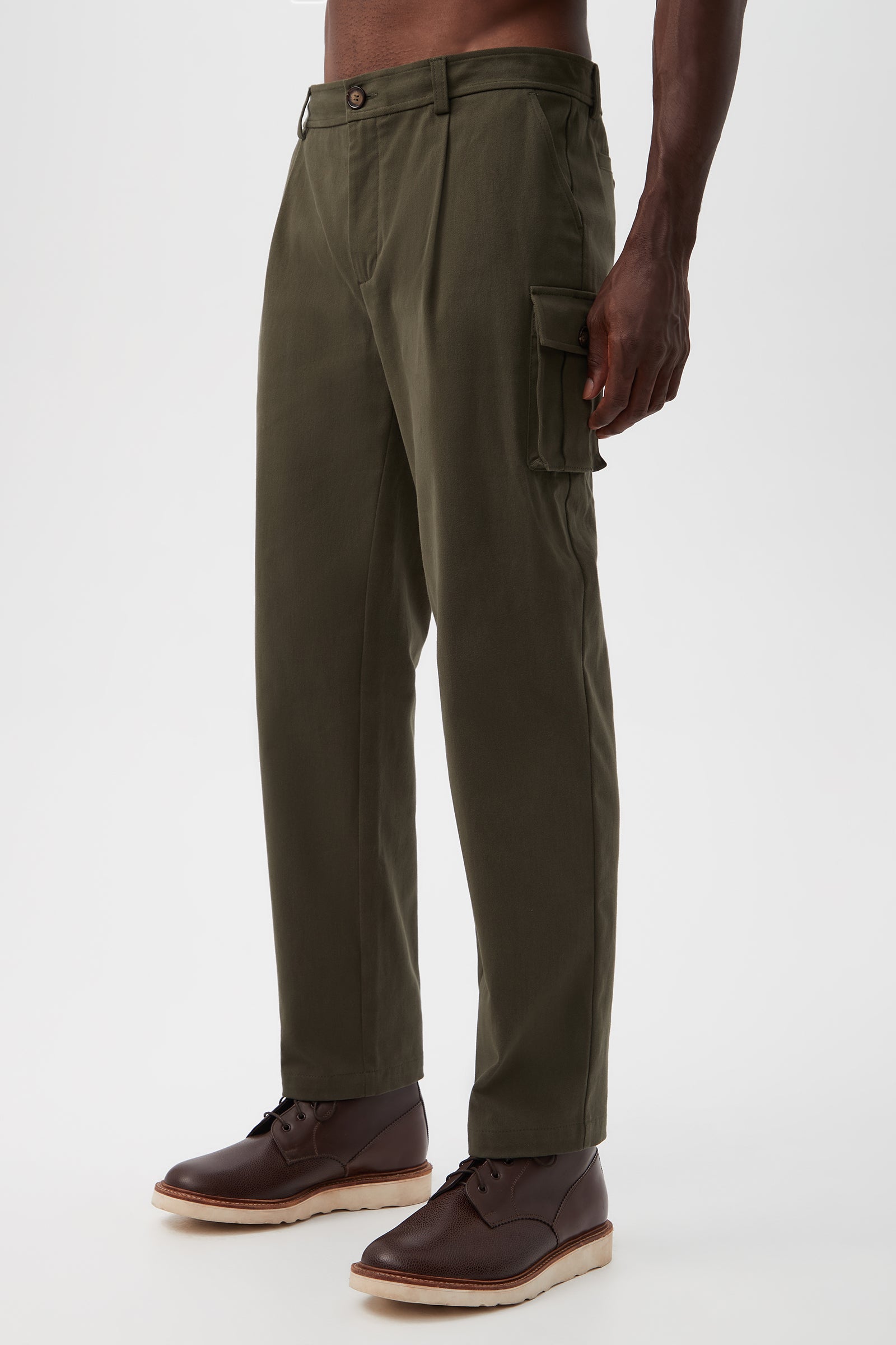 A person in Lincoln Heights Cargo Trouser - Brushed Twill with side pockets and brown lace-up shoes stands against a plain white background.