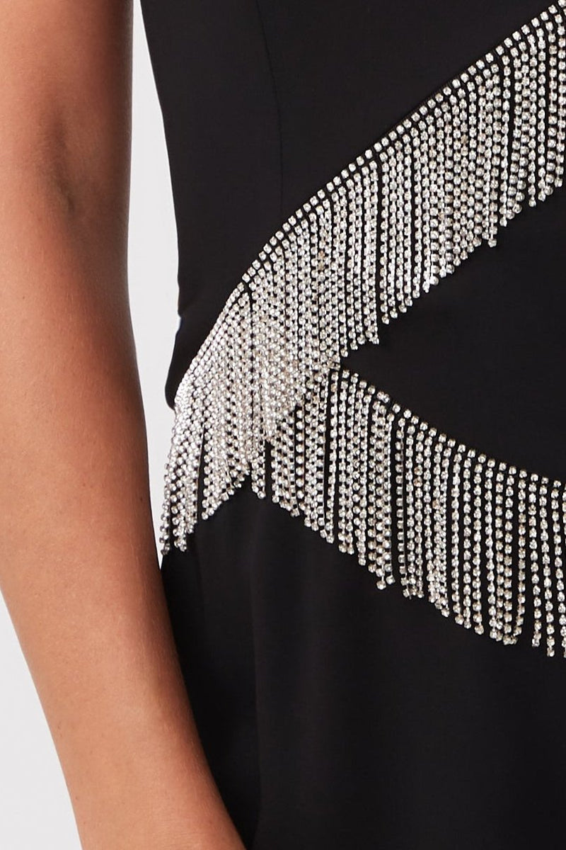 Close-up of a person wearing the Aeris Rhinestone Fringe Strapless Top, featuring two diagonal rows of silver rhinestone fringe. Only the arm and part of the top are visible.