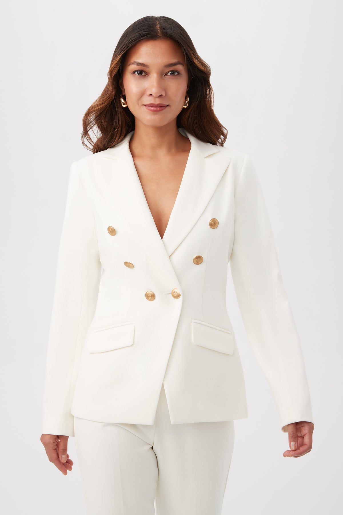 A woman wears the Midlands Luxe Drape Stretch Blazer Jacket in WINTER WHITE with matching pants, standing against a plain light background and looking confidently at the camera.
