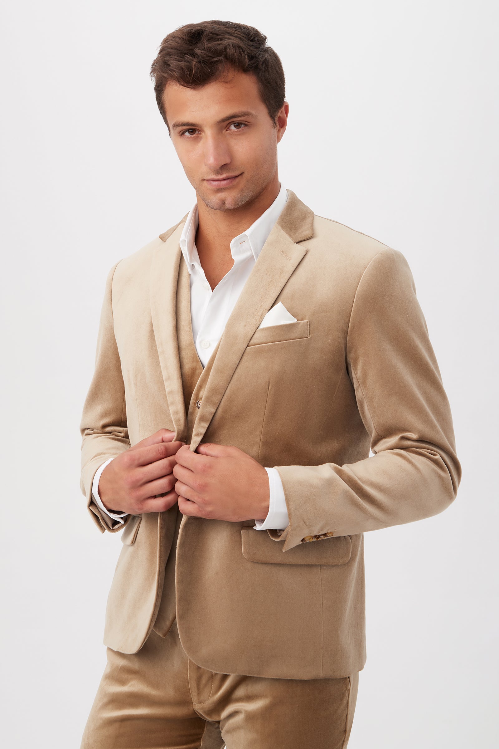 A man poses confidently in the Thurston Blazer - Gold Velveteen, paired with a white dress shirt and pocket square, against a plain white background.