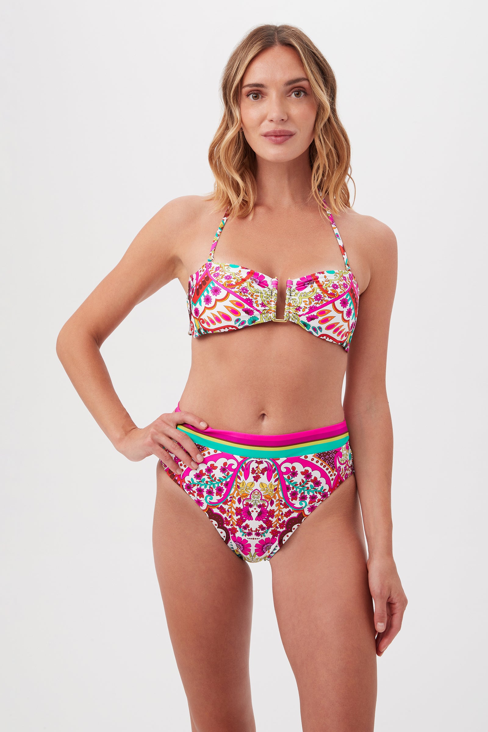 A woman smiles gently with one hand on her hip, wearing the Hawaiian Garden U-Wire Strapless Bandeau Swim Top in Multi, paired with high-waisted bikini bottoms, standing against a plain white background.