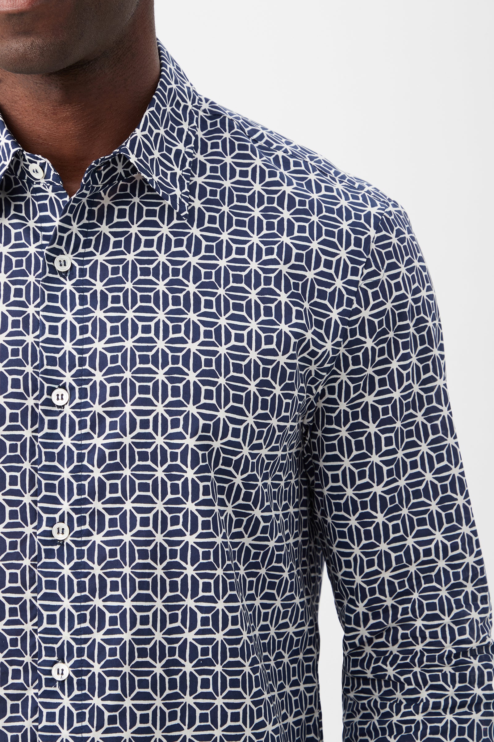 A man models the Aaron 2 Slim Long-Sleeve Shirt—a navy blue button-up featuring a white geometric pattern of interlocking circles and squares—shown from shoulders to waist against a plain background.
