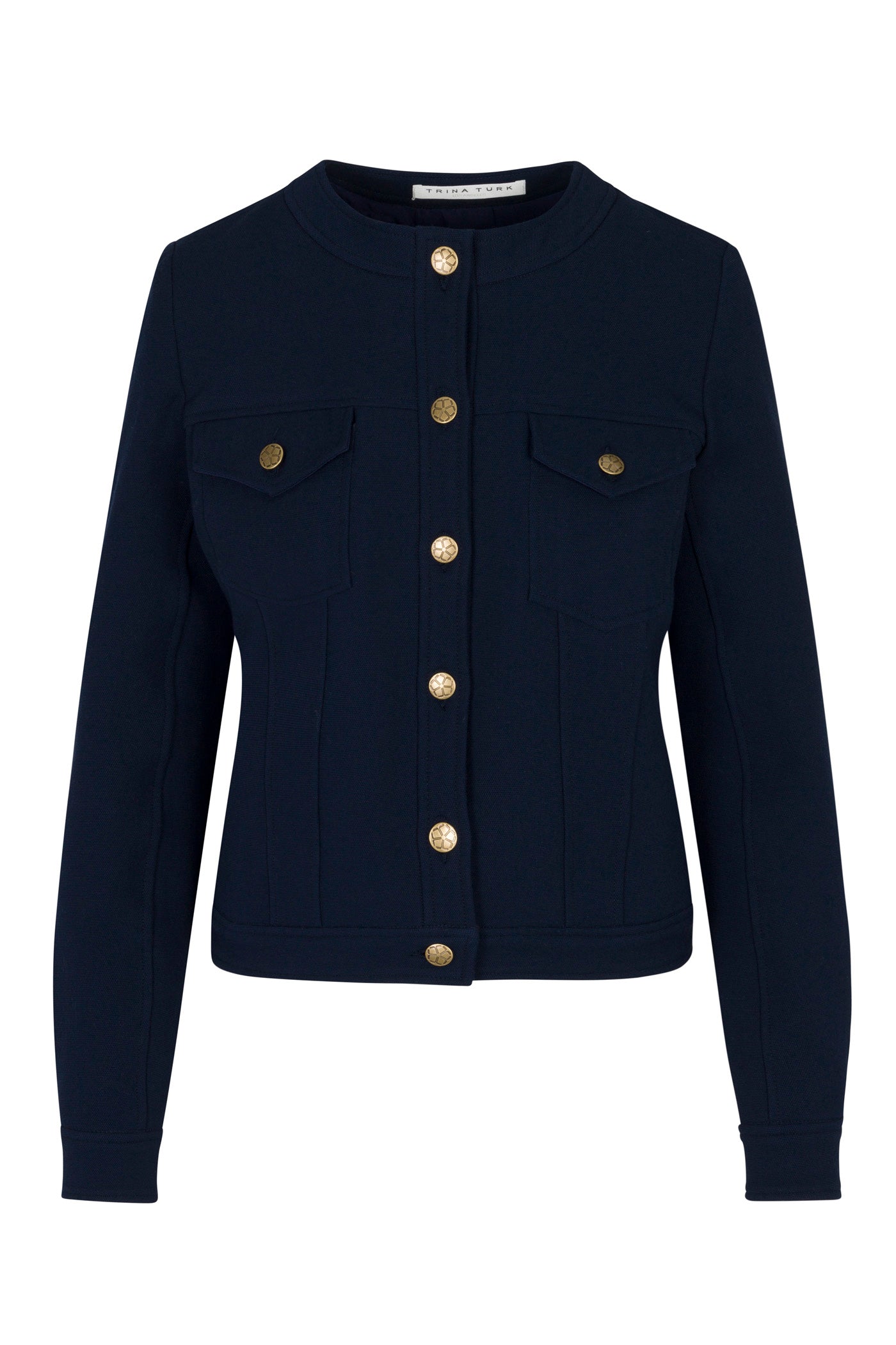 The Gail Jacket is a fitted, long-sleeve navy jacket featuring a round neckline, two chest pockets with flaps, and gold buttons down the front and on the pockets.