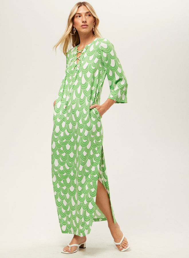 Woman wearing a green patterned dress on a white background