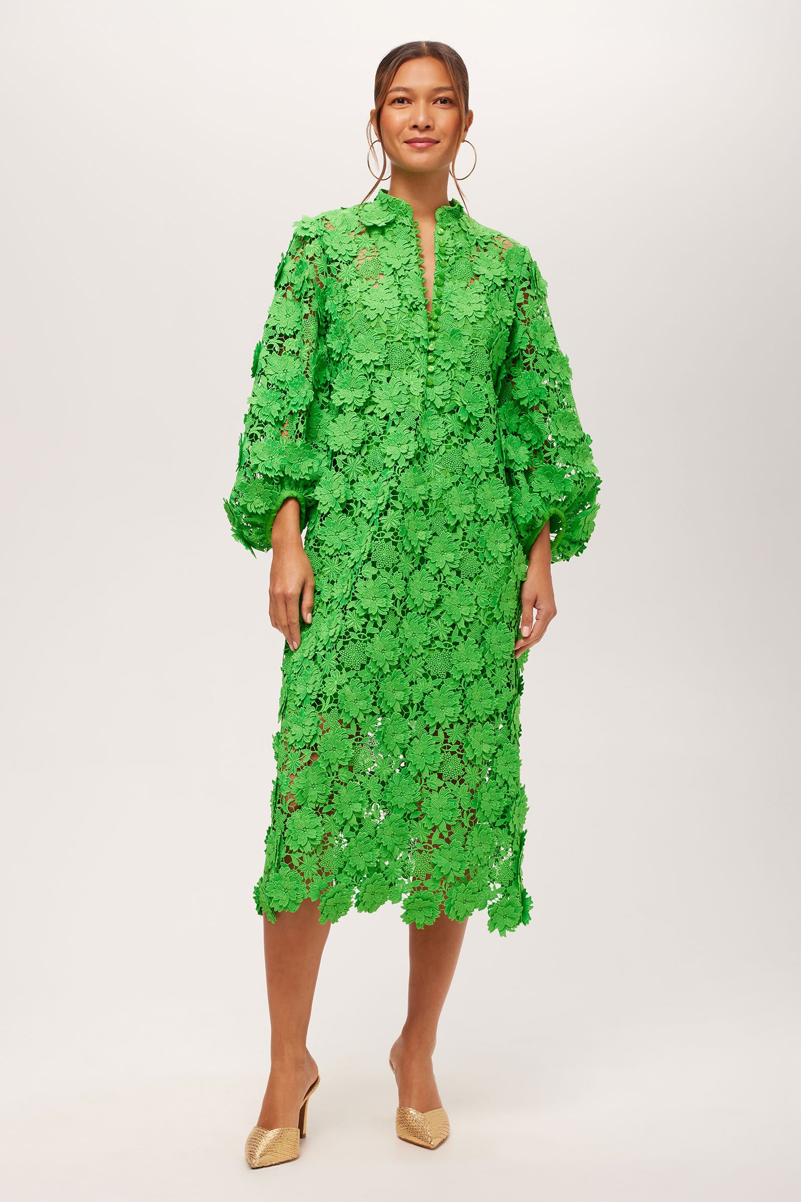 A woman wears the Boheme 3/4-Sleeve Midi Dress in Grass Court Green, featuring allover lace and a midi length. She pairs it with gold hoop earrings and beige low-heeled shoes against a plain, light background.