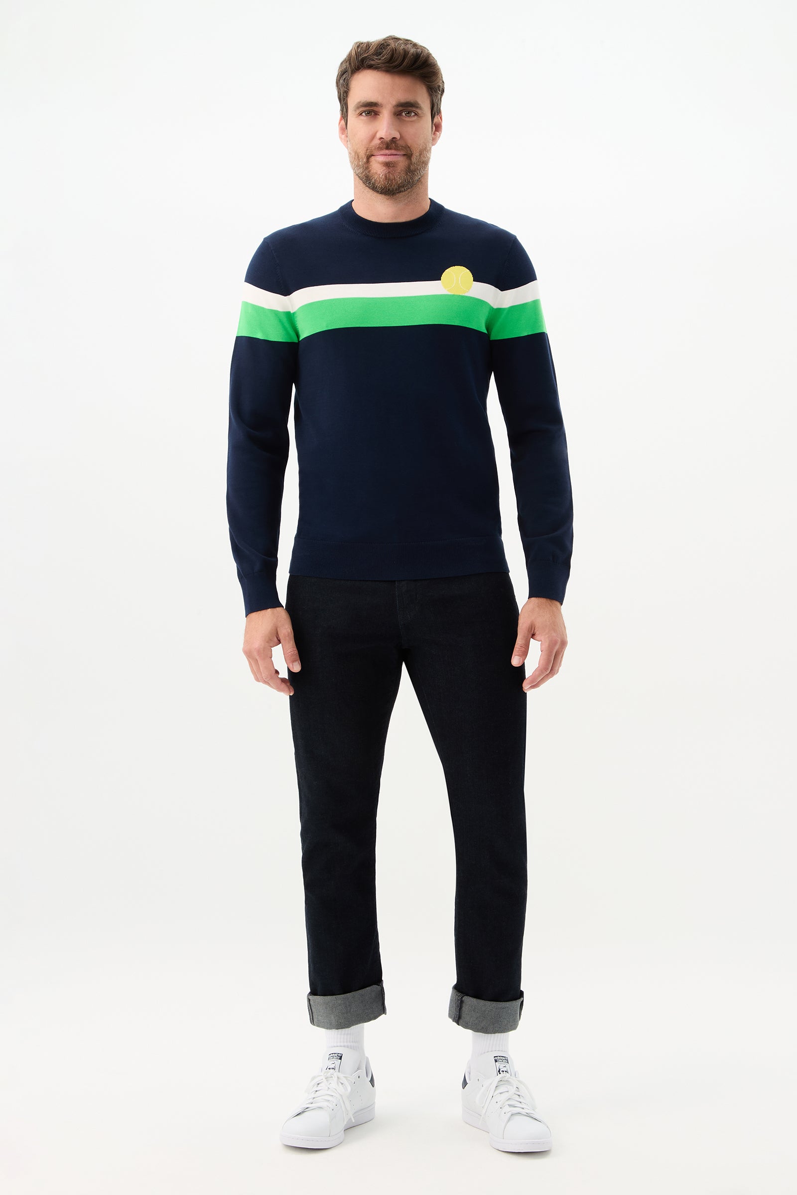 A man wearing a Romero Crewneck Sweater and black pants.