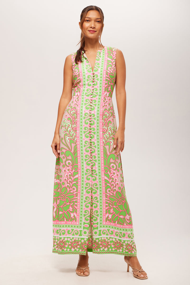 A woman stands against a plain white background wearing the Novak Sleeveless Midi Dress in Petra Floral and nude heeled sandals.