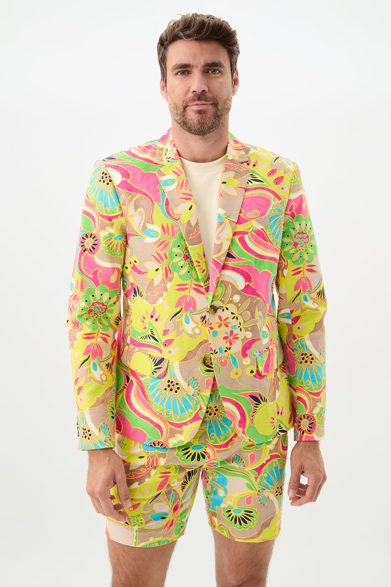 A man with short brown hair and a beard stands against a plain white background wearing the Venus-colored Thurston Blazer and matching shorts; his expression is neutral.