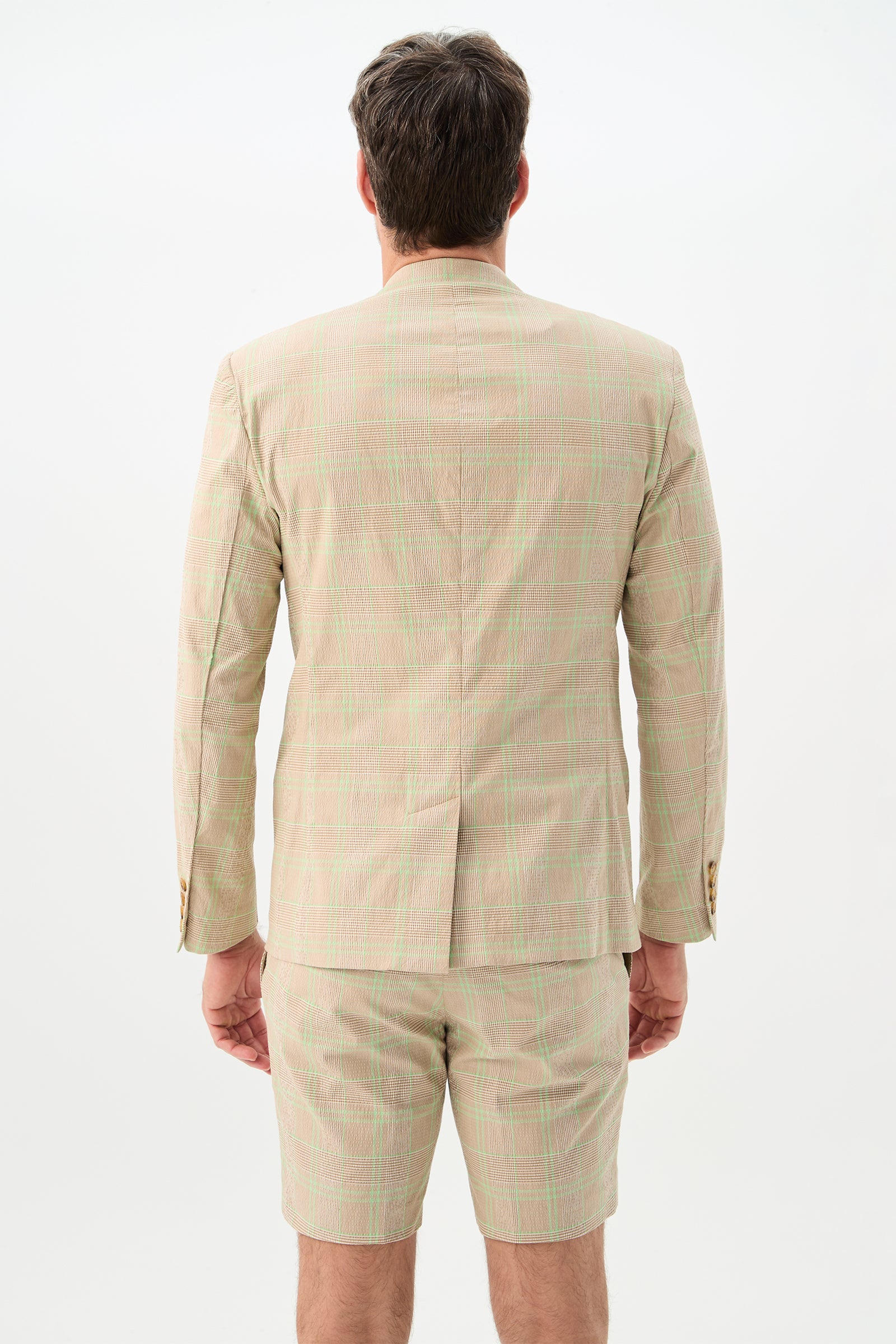 A man faces away from the camera, wearing the Louie Blazer - Zianieri Plaid suit jacket with matching shorts against a plain white background.