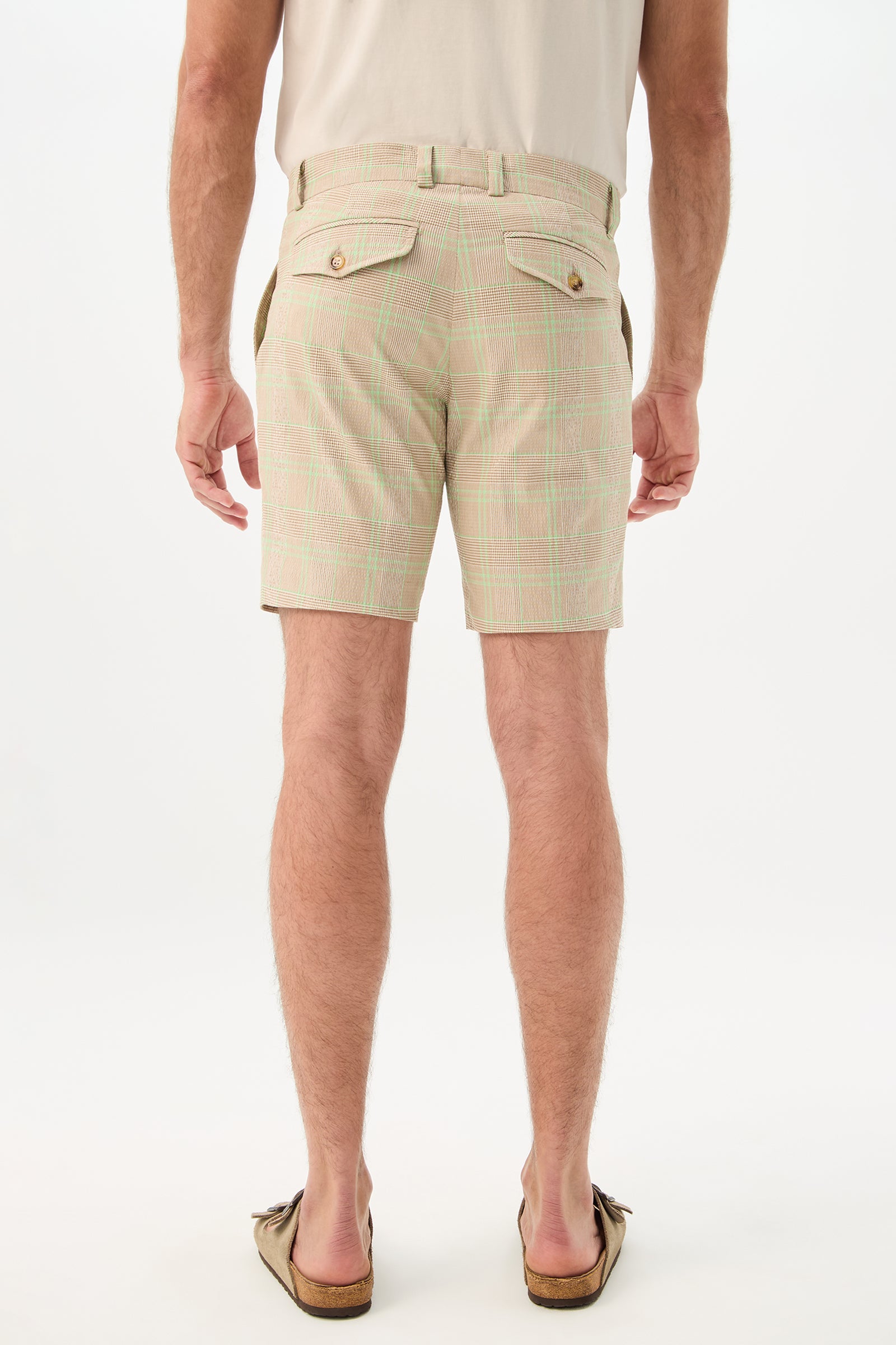 A person is shown from the back wearing Travis Short - Zianieri Plaid with buttoned back pockets, a beige tucked-in shirt, and brown slip-on shoes against a plain white background.