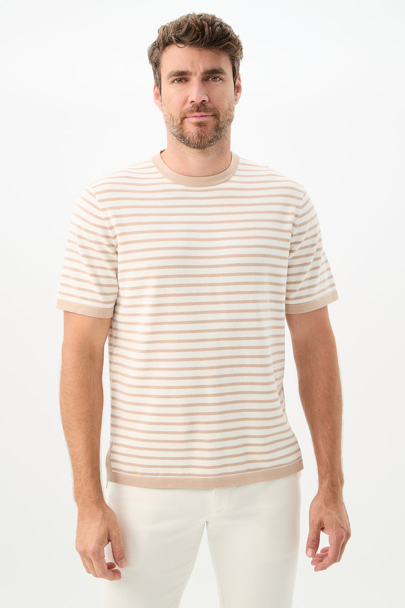 A man with short brown hair and a beard wears the Giovanni Stripe Short-Sleeve Pullover in Beach/Whitewash and white pants, standing against a plain white background.