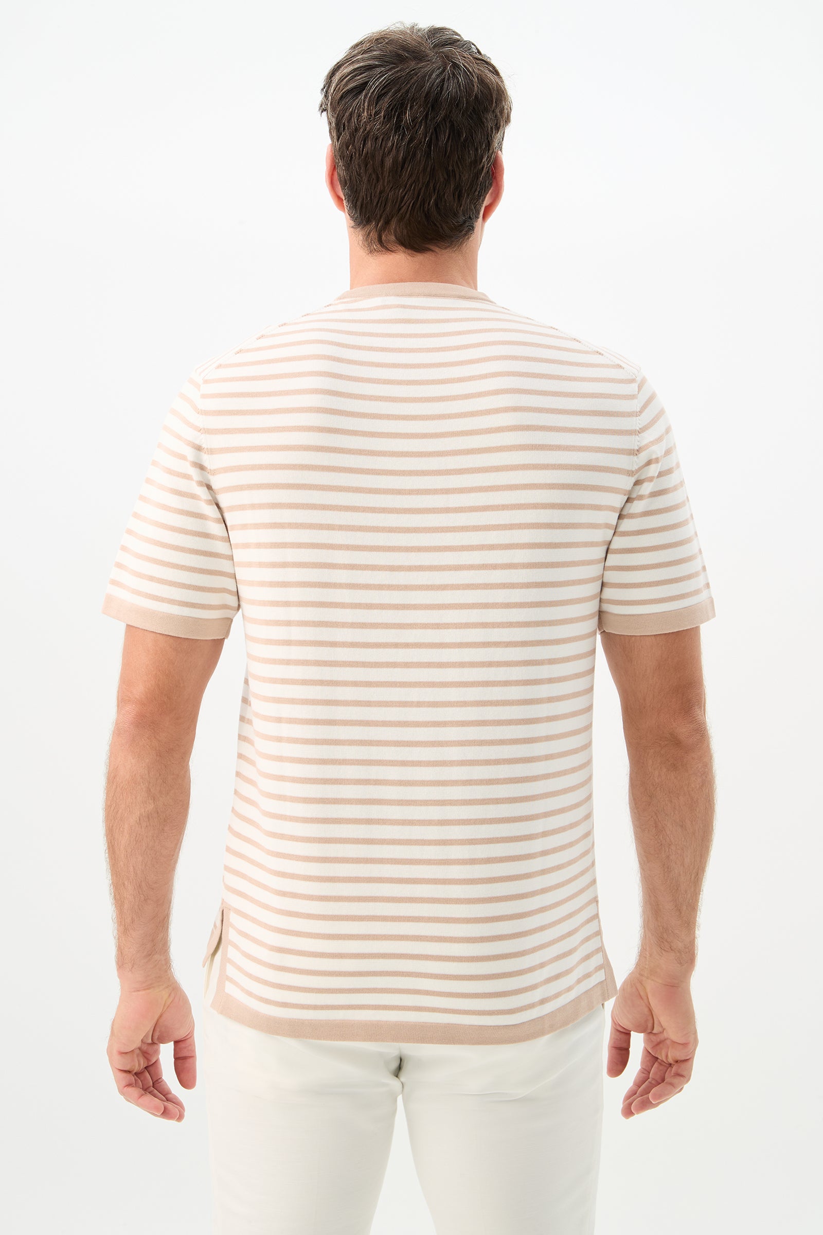 A man with short brown hair, seen from behind, wears the Giovanni Stripe Short-Sleeve Pullover in beige and white stripes with white pants against a plain white background.