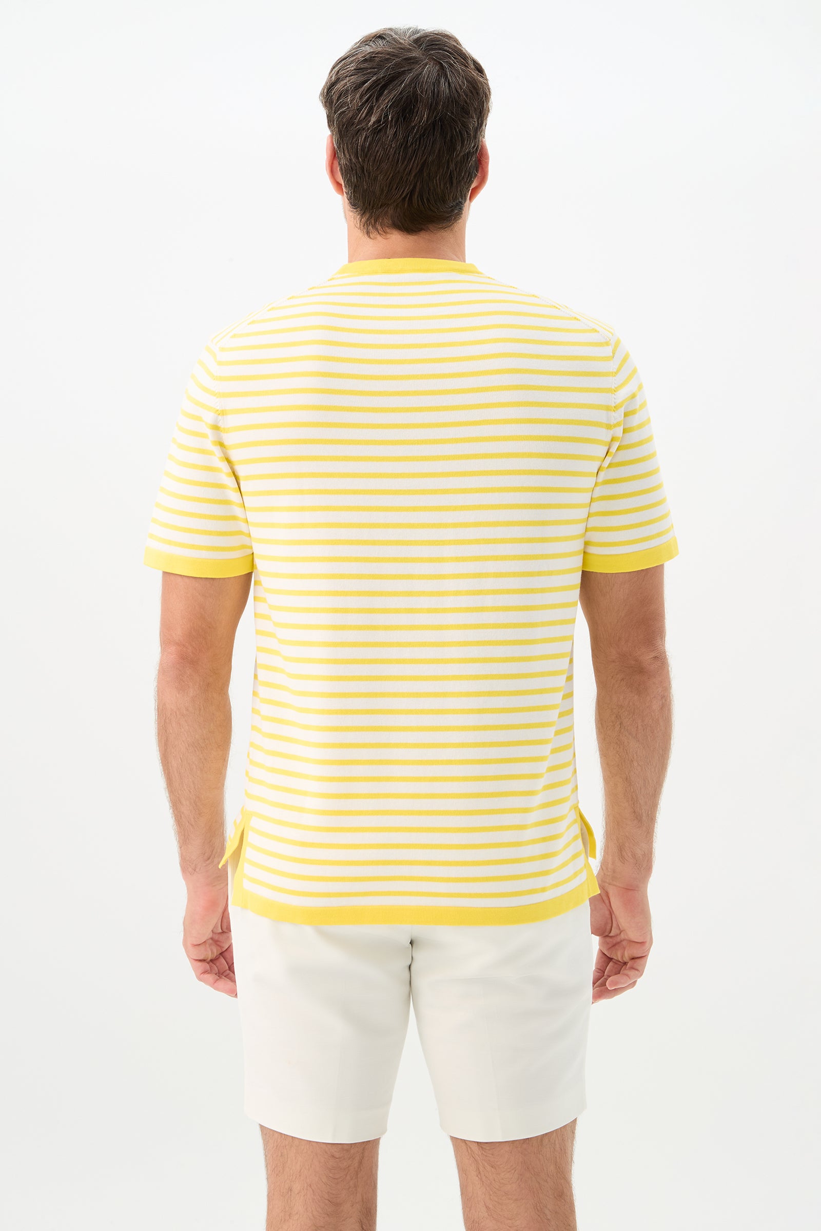 A man stands facing away, wearing the Giovanni Stripe Short-Sleeve Pullover in yellow and white stripes with white shorts, set against a plain white background.