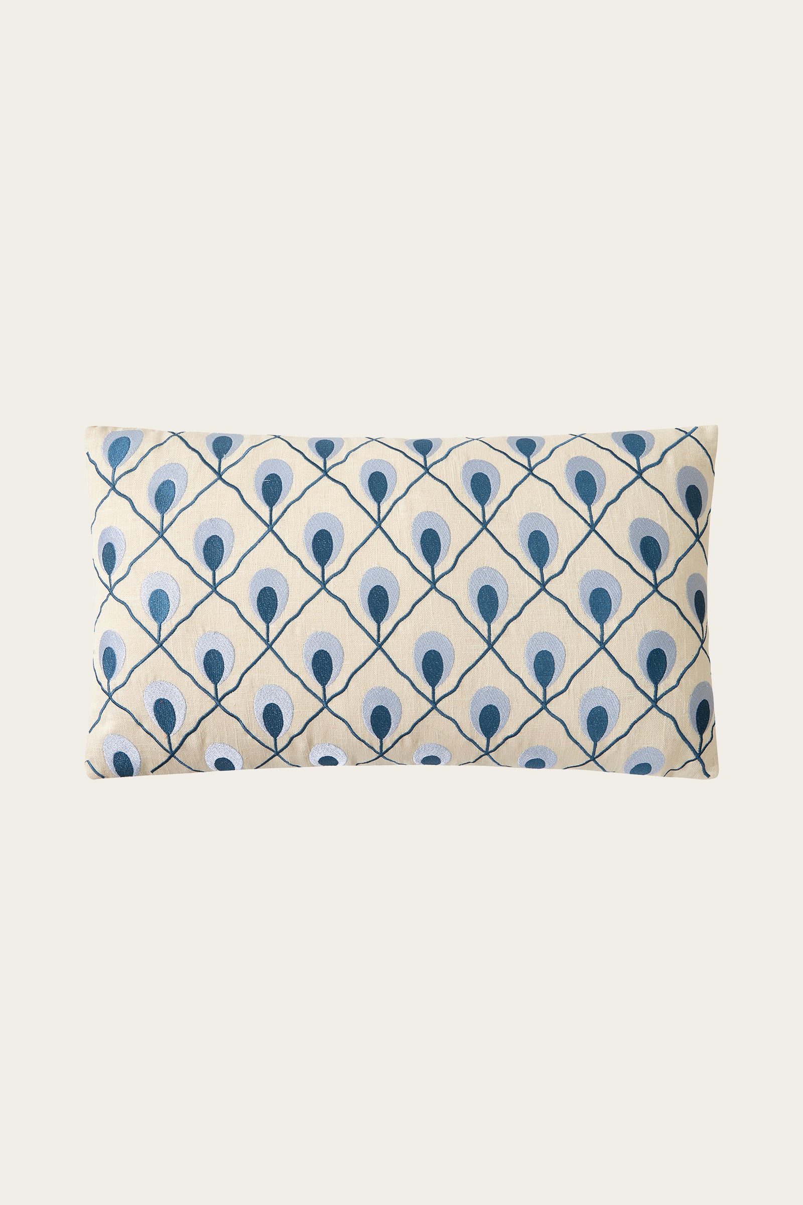 The Roseville Embroidered Throw Pillow - Terra features a rectangular shape with a terracotta background and a repeating embroidered pattern inspired by peacock feathers, arranged in a geometric grid.