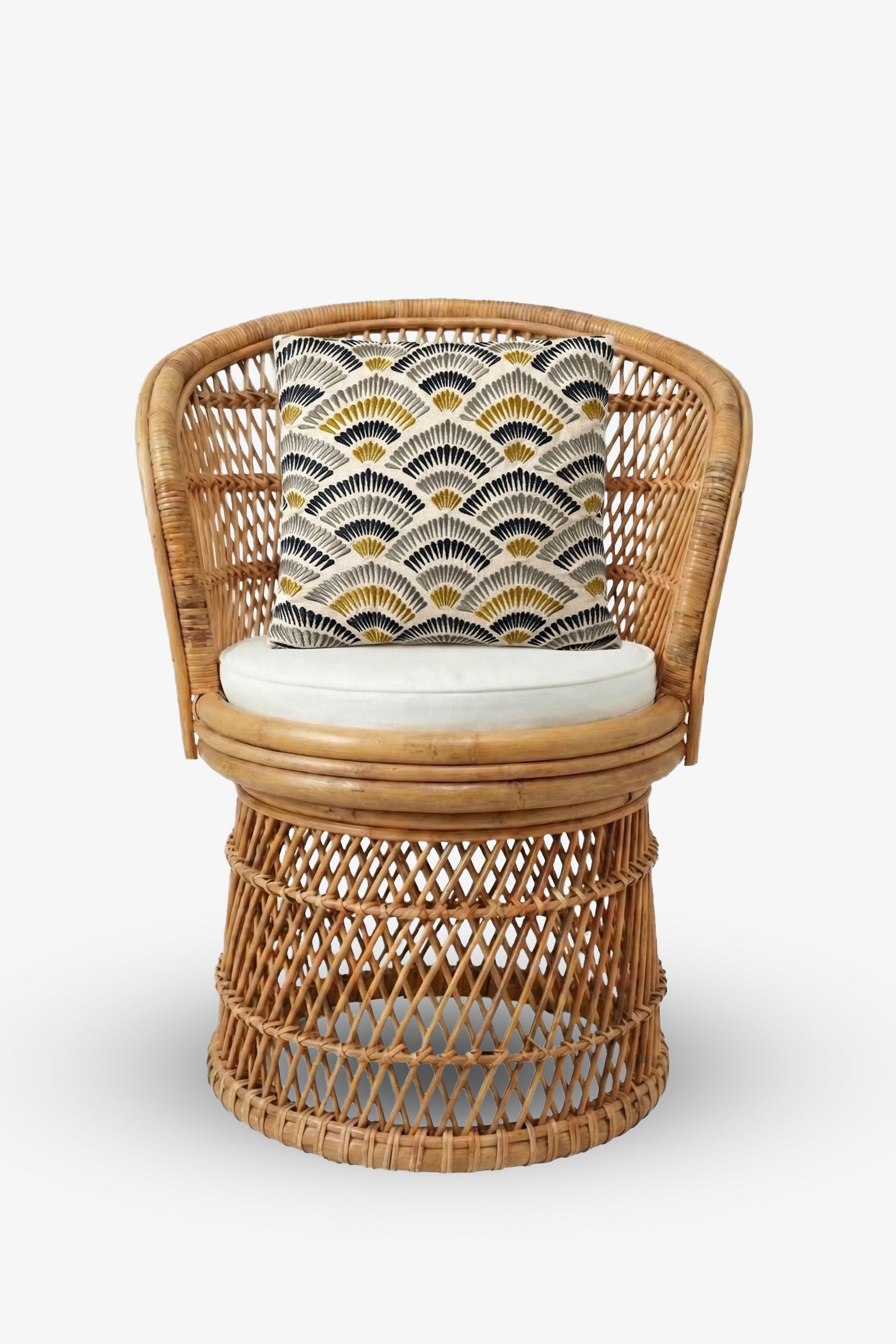 A round wicker chair with a white seat cushion and a Pasadena Embroidered Square Pillow, which features a black, white, and yellow geometric fan pattern, set against a plain white background.