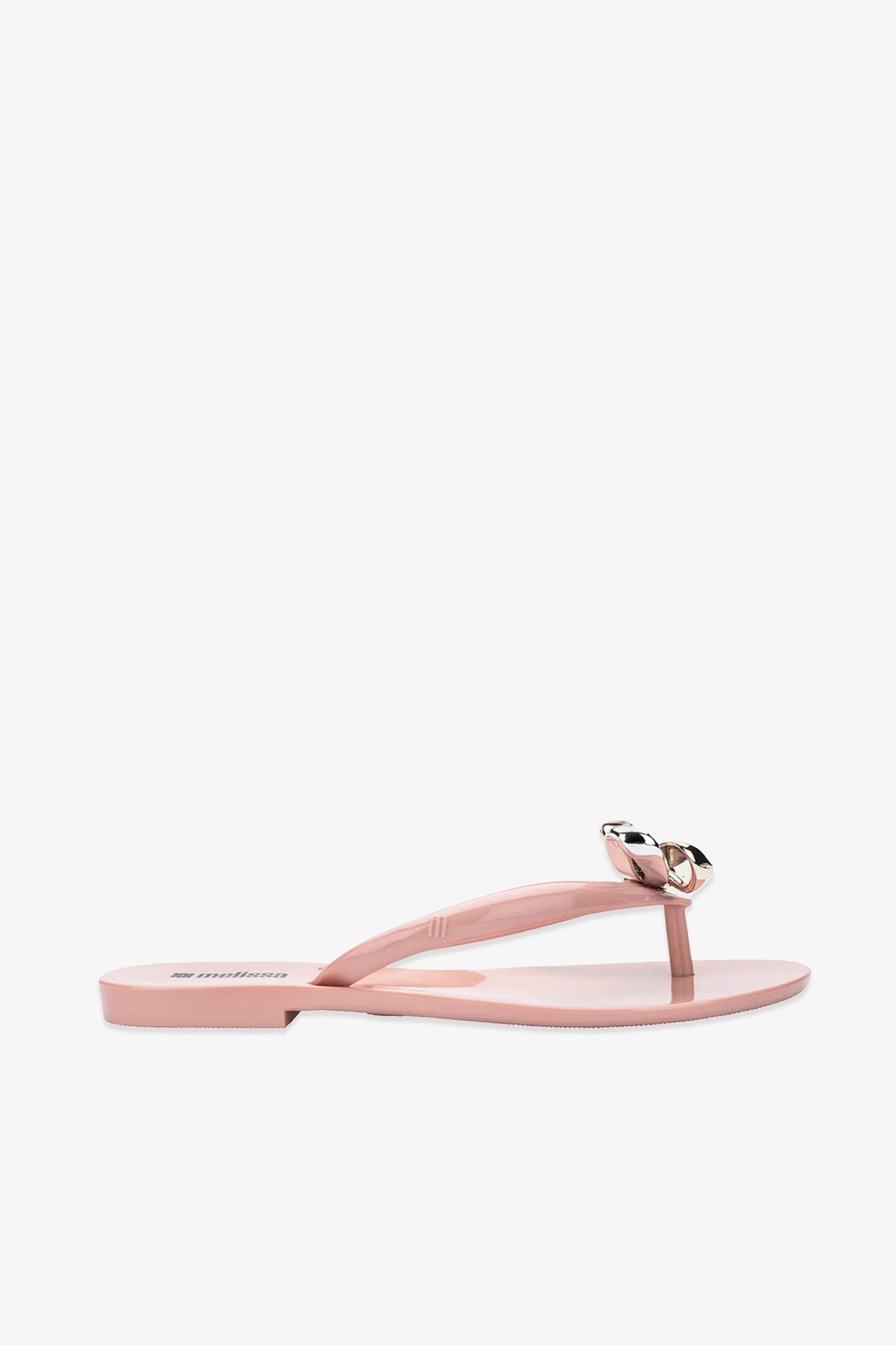 The Melissa Harmonic Eclipse Bow Sandal in pink features a flat thong design with a striking metallic chain detail on the strap, showcased against a white background.