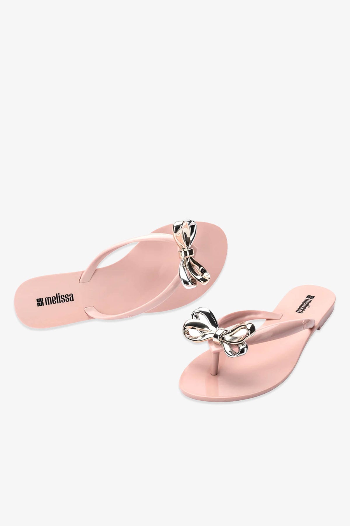 A pair of Melissa Harmonic Eclipse Bow Sandal in pink, featuring metallic bow decorations on the straps, displayed on a white background.