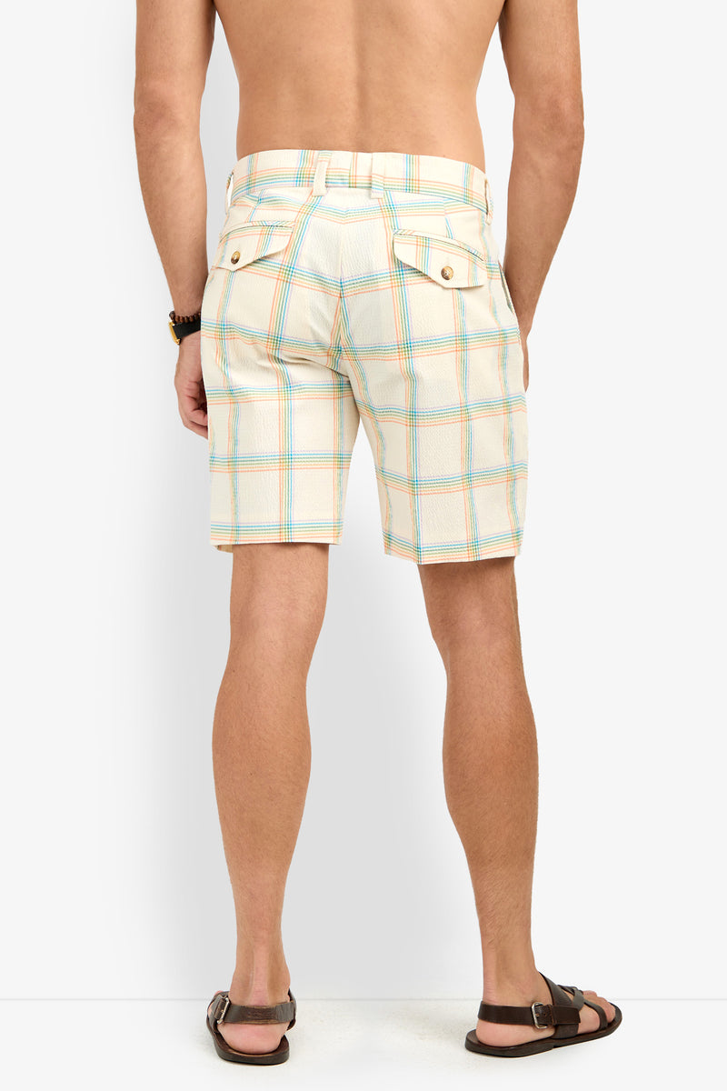 A man wearing the Travis Short - Pride Plaid with buttoned back pockets stands barefoot, facing away from the camera against a white background.