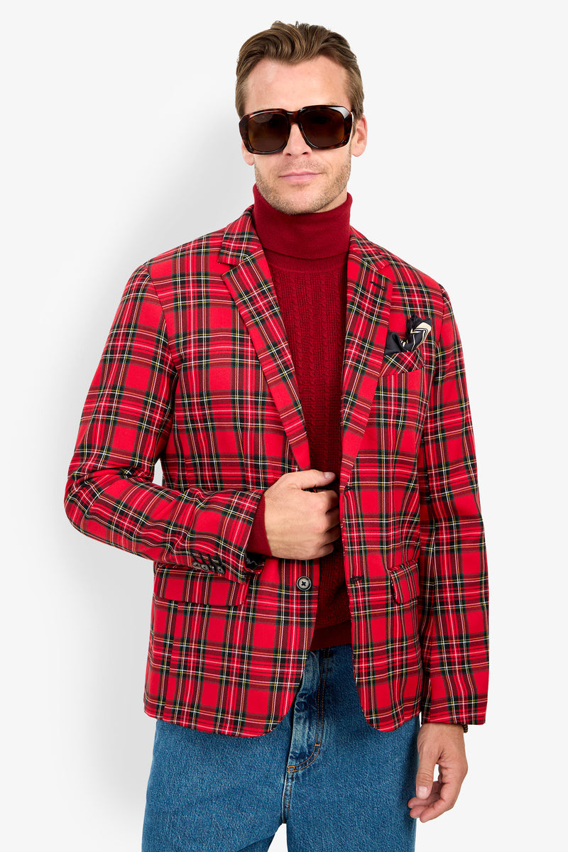 Man wearing large sunglasses, the Thurston Blazer in red plaid over a red turtleneck, and blue jeans, standing against a plain white background.