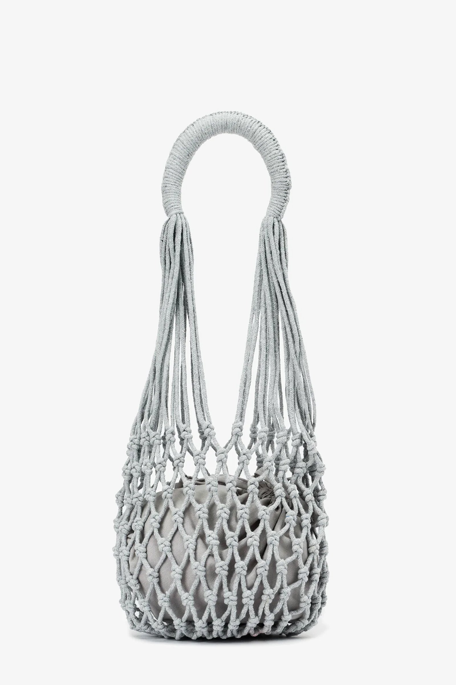 Introducing the Nannacay Kim Woven Bag—a light gray, knotted rope handbag featuring a circular handle and an open, net-like design with a compact inner pouch.