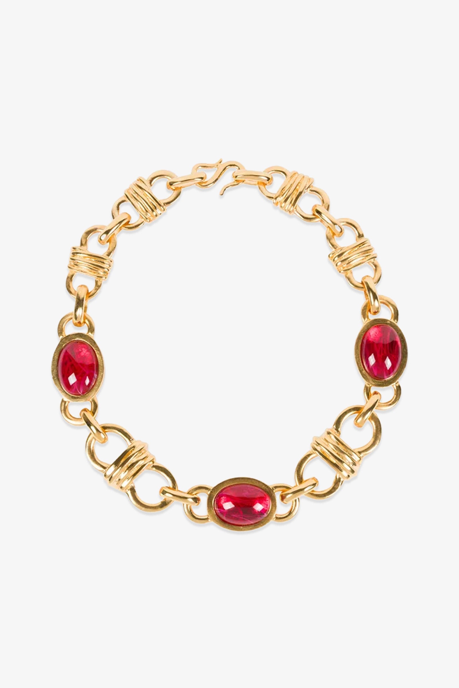 The Ruby Oval Link Necklace features four evenly spaced oval red gemstones set among decorative gold links, and is secured with a hook clasp.