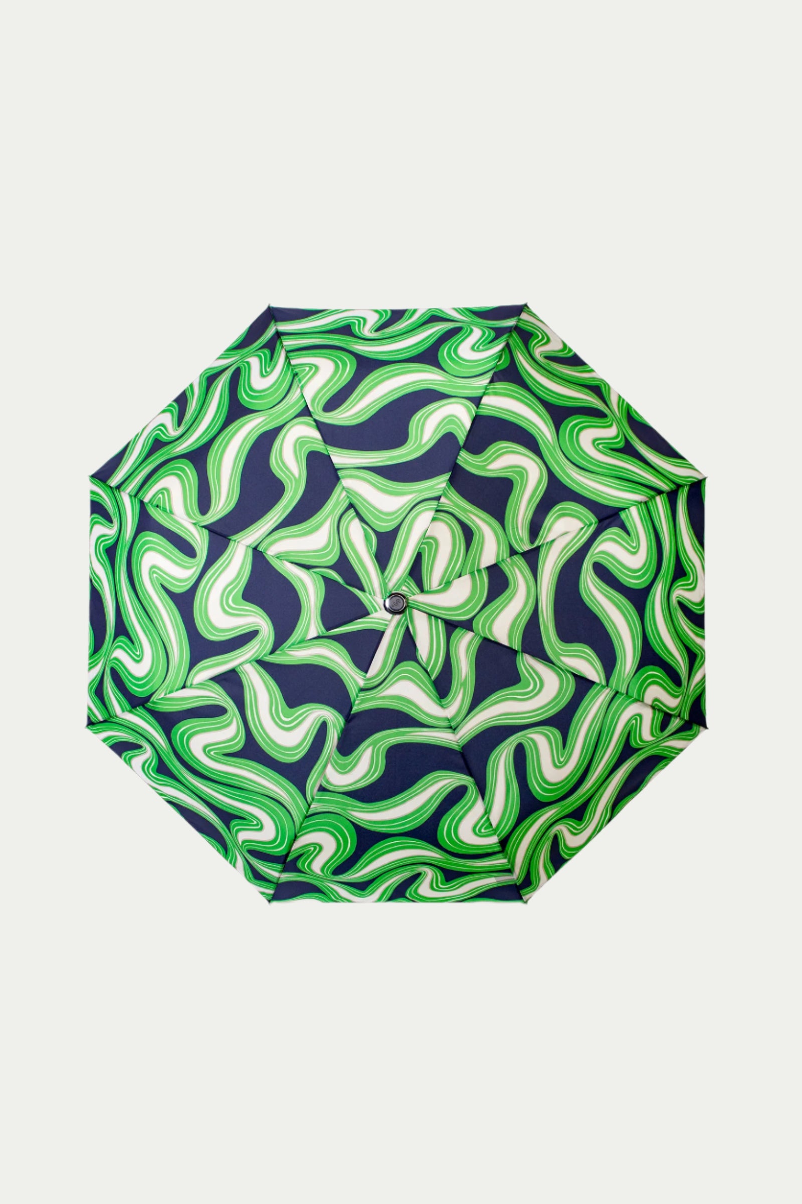 The TT X SR Compact Umbrella - Serena Satin features a bold, wavy pattern in green and white on a dark background, creating a swirling, psychedelic effect when viewed from above.